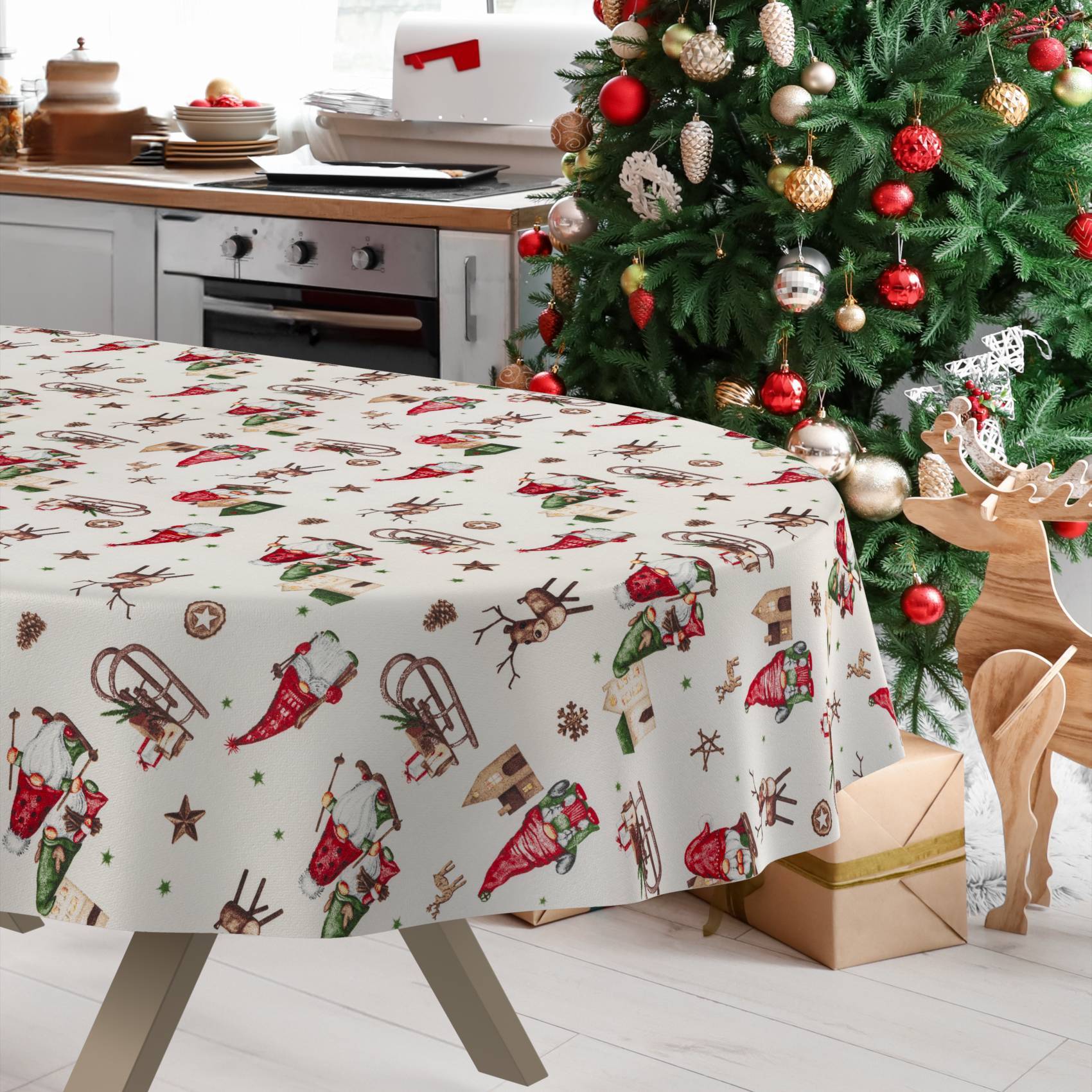Weihnachtlich dekorierte Küche mit einem Tisch, der mit einer festlichen Weihnachtsmannmuster-Tischdecke bedeckt ist, neben einem dekorierten Baum und einer Rentierverzierung.