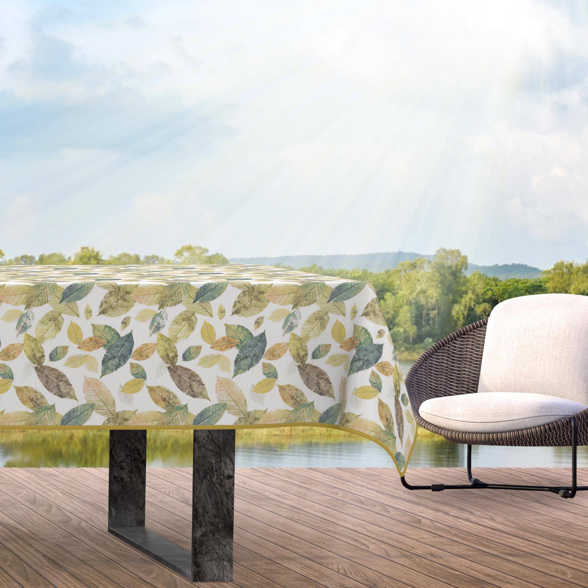 Terrasse im Freien mit einer Tischdecke mit Blattmuster auf einem Tisch und einem gepolsterten Stuhl vor einer sonnigen landschaftlichen Kulisse.