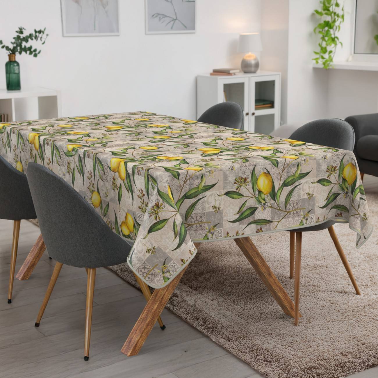 Esstisch mit einer zitronenmusterten Tischdecke, umgeben von grauen Stühlen in einem modernen Wohnzimmer.