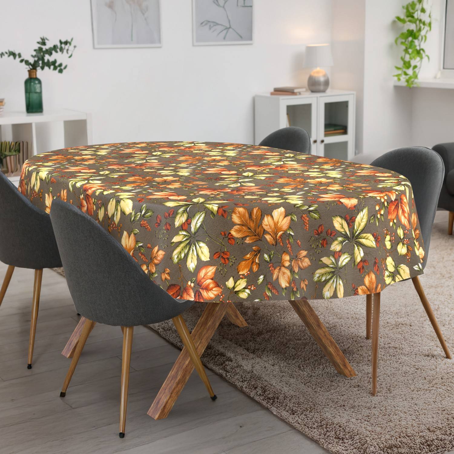 Esstisch mit einer Tischdecke im Herbstlaubmuster, umgeben von dunklen Stühlen in einem hell erleuchteten modernen Raum.