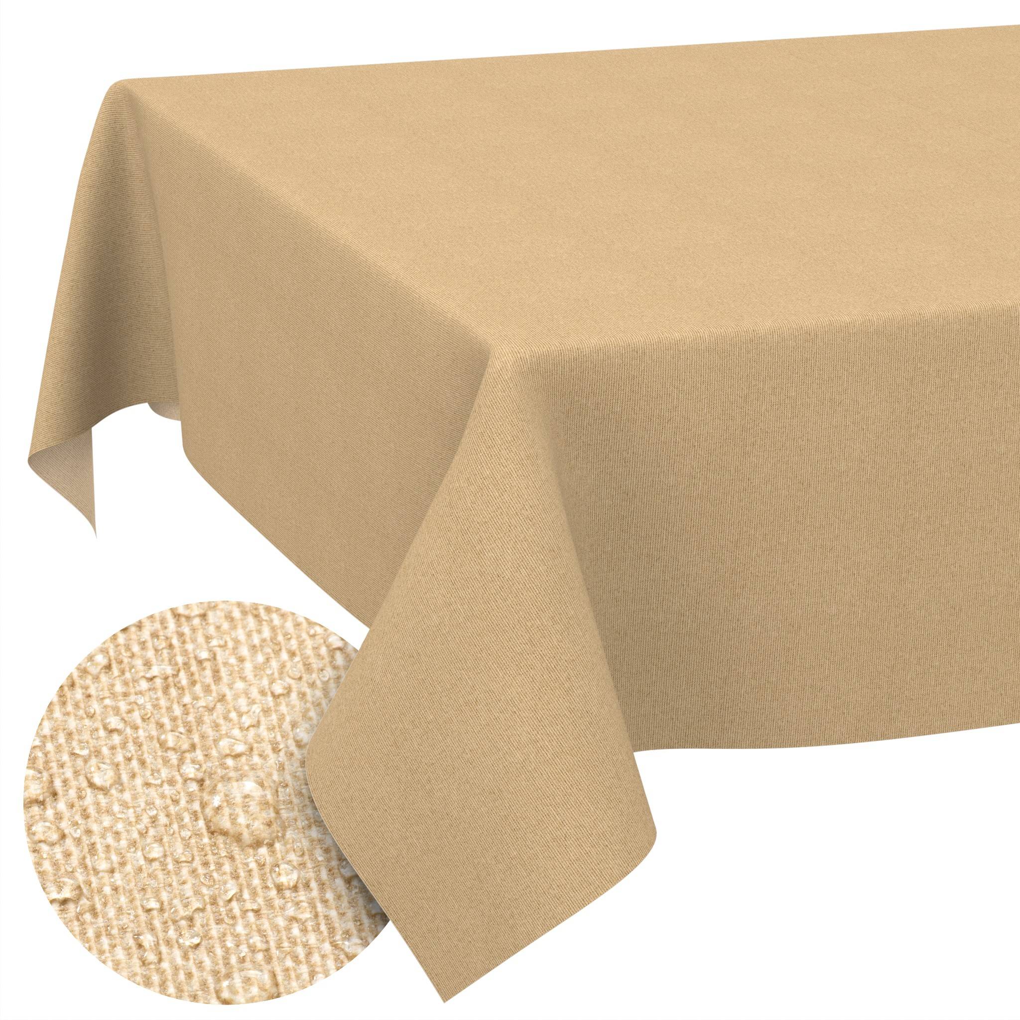 Ein beiges Tischtuch, das über einen Tisch drapiert ist, mit einer runden geflochtenen Platzdecke oder einem Untersetzer, der teilweise unten links sichtbar ist.