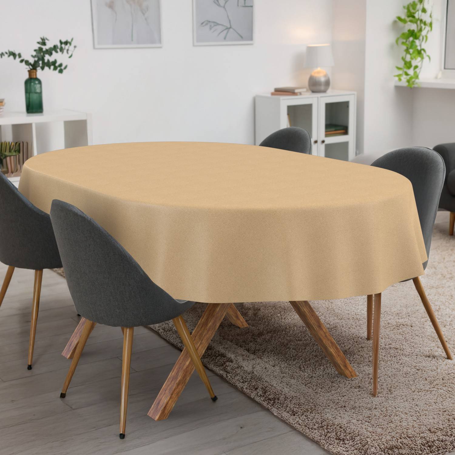 Esszimmer mit einem ovalen Tisch, bedeckt mit einer beigefarbenen Tischdecke, umgeben von dunkelgrauen Stühlen auf einem Teppich.