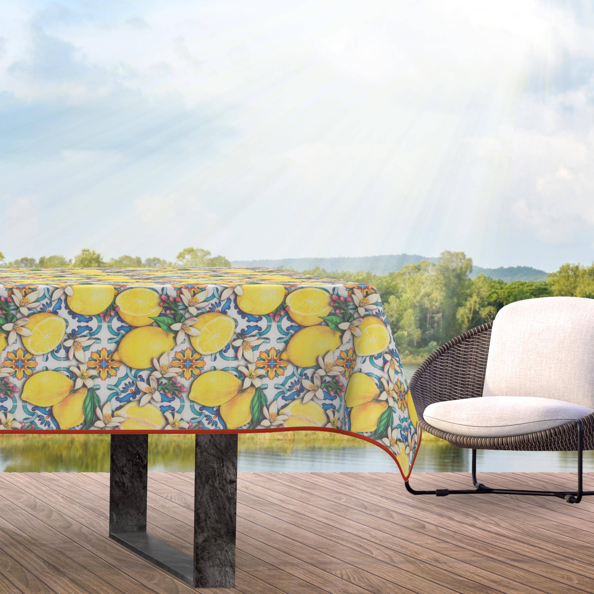 Außenbereich-Szenerie mit einem Tisch, der mit einer Tischdecke mit Zitronenmuster bedeckt ist, und einem weißen Stuhl, mit Blick auf eine sonnige grüne Landschaft und entfernte Hügel.