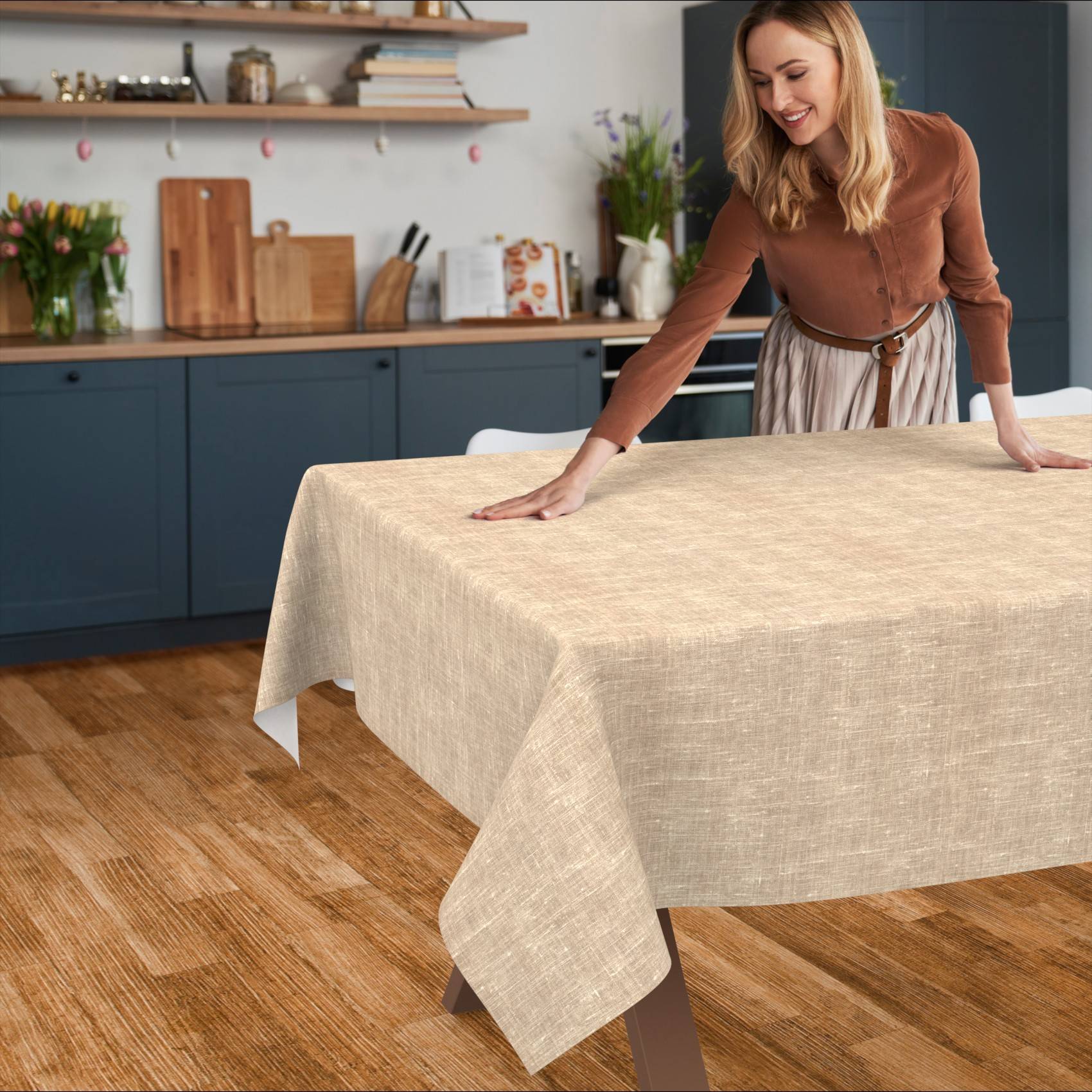 Frau glättet eine beige Tischdecke über einen Esstisch in einer modernen Küche.