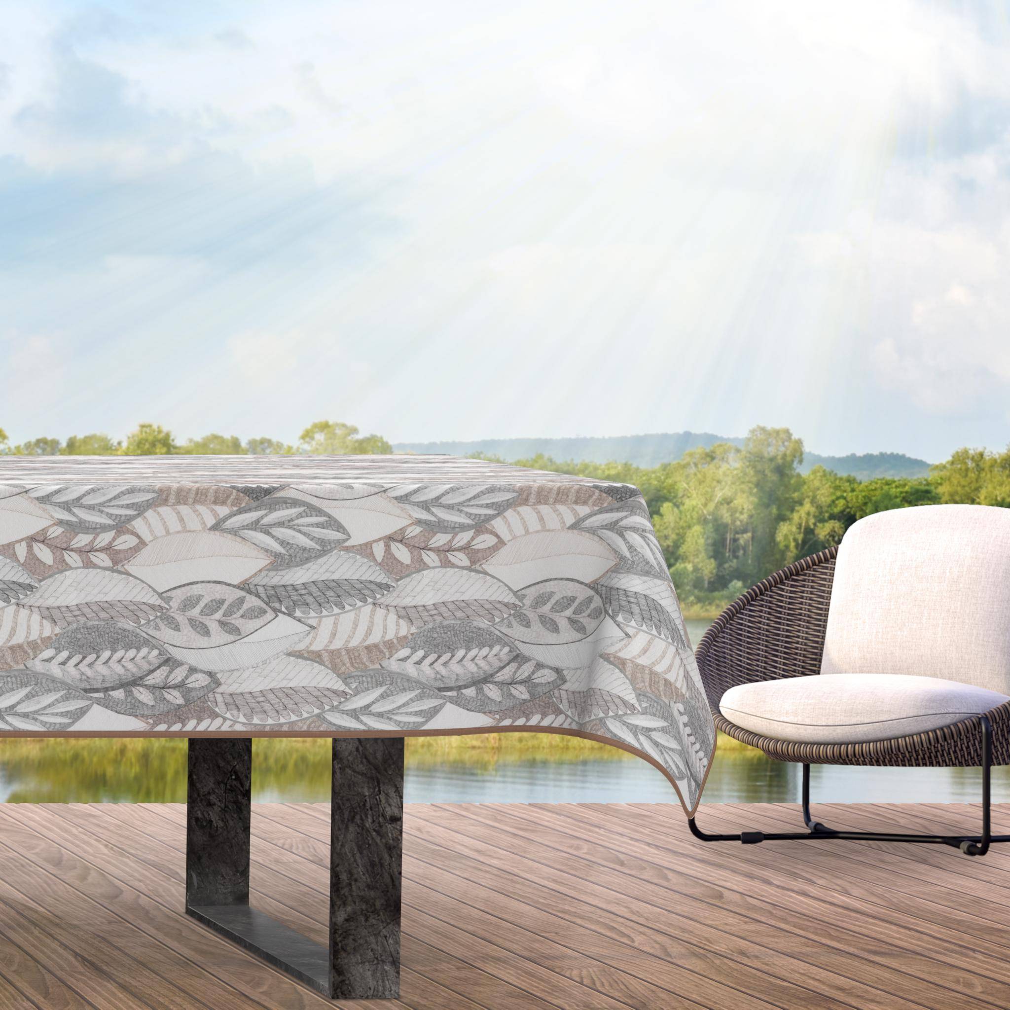 Outdoor-Terrasse mit blattgemusterter Tischdecke und gepolstertem Stuhl mit Blick auf eine helle Landschaft und Wasser