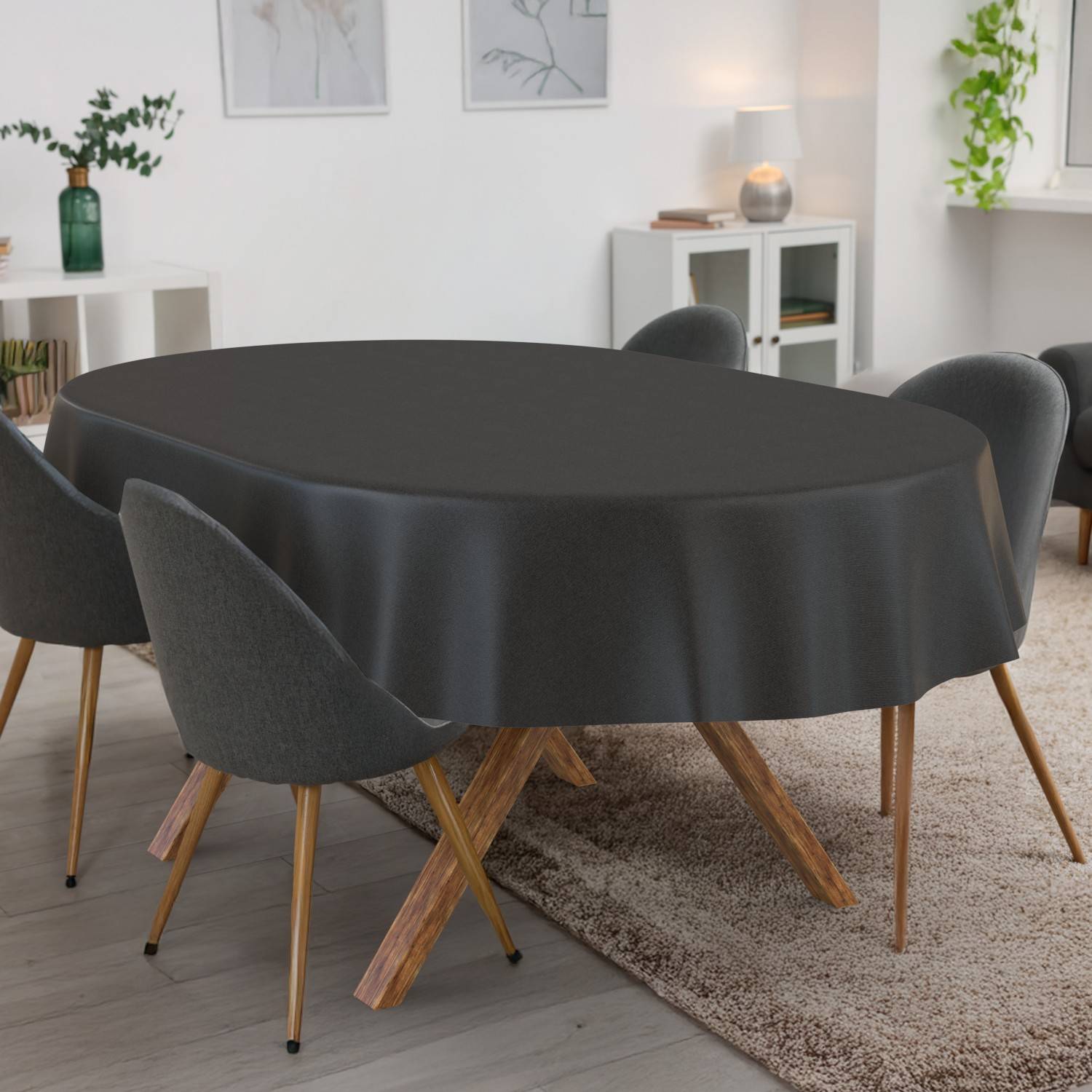 Esstisch mit schwarzer Tischdecke, umgeben von vier grauen Stühlen in einem modernen Wohn-Esszimmer.