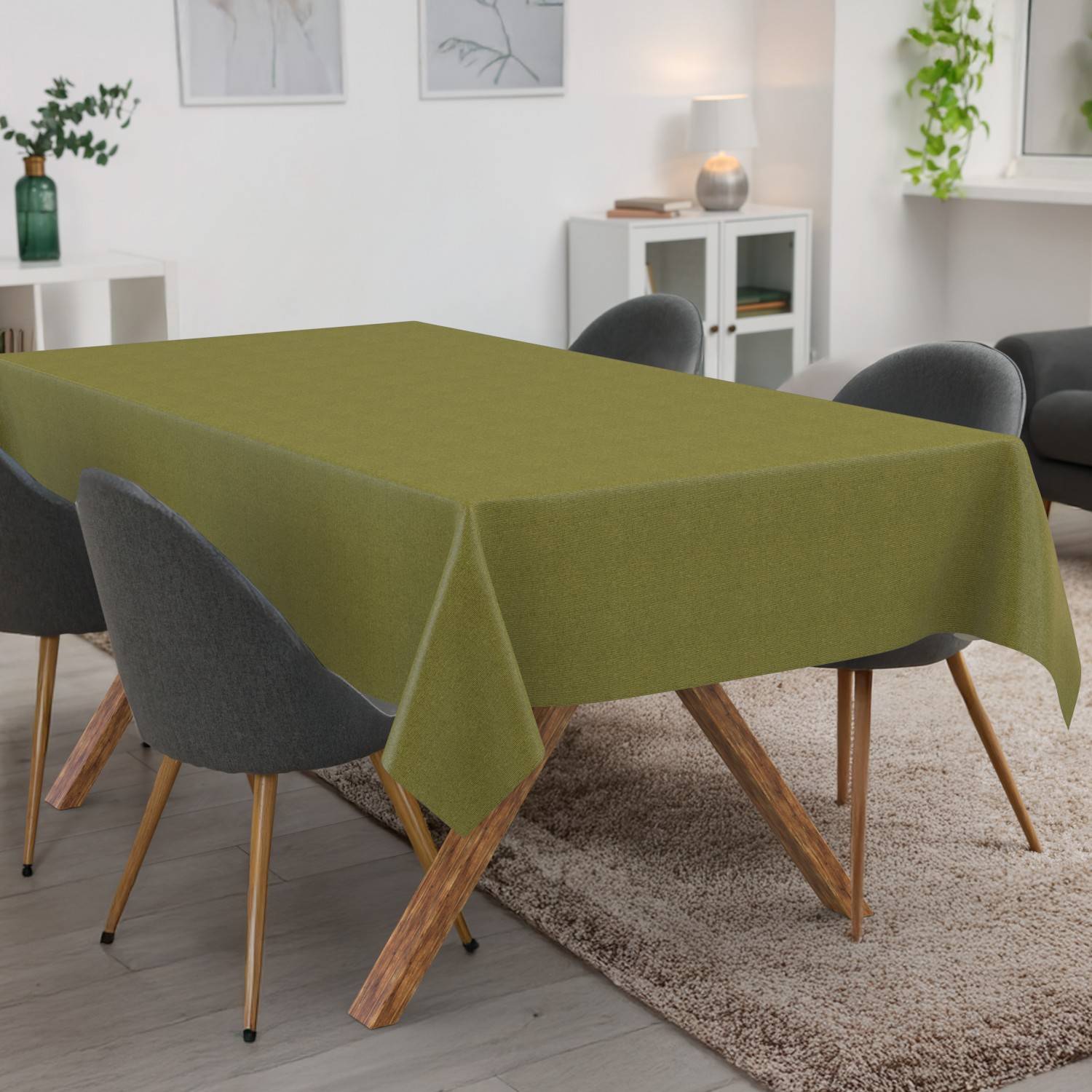 Esstisch mit olivgrüner Tischdecke in einem modernen Raum, umgeben von dunkelgrauen Stühlen auf einem Teppich.