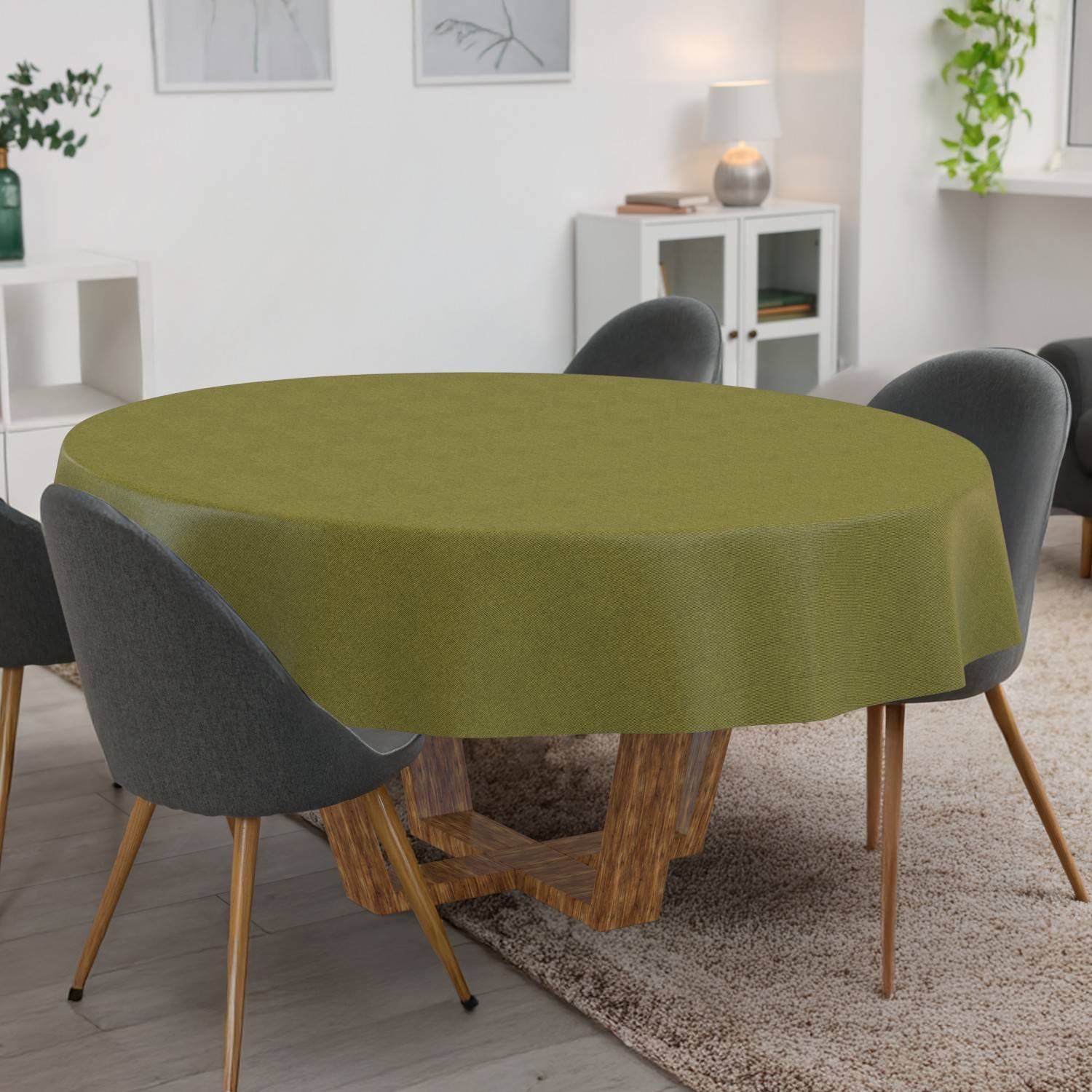 Runder Esstisch mit olivgrüner Tischdecke, umgeben von vier grau gepolsterten Stühlen in einem modernen Wohn-/Esszimmer.