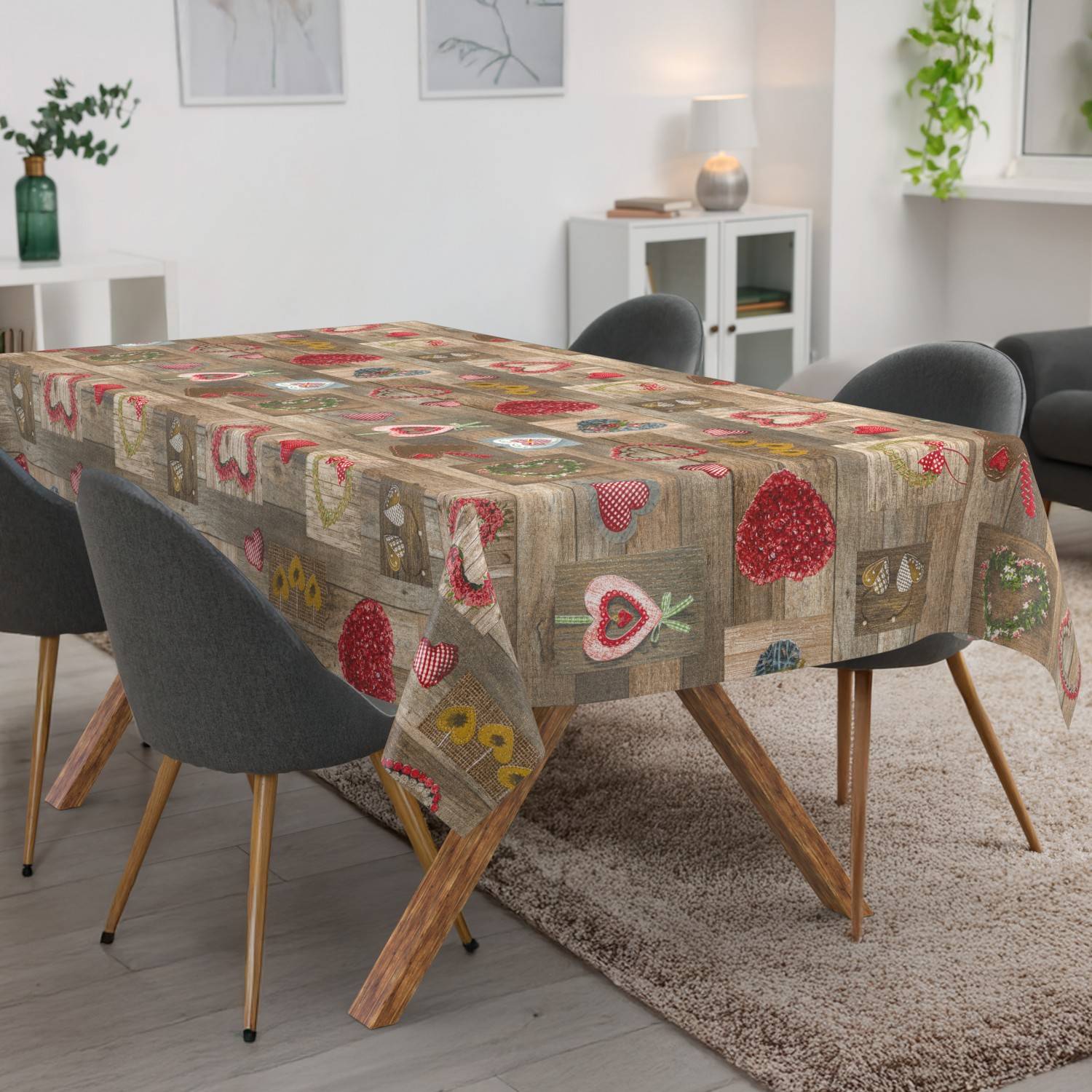 Rechteckiger Esstisch mit einer gemusterten Patchwork-Tischdecke in einem hellen modernen Wohnzimmer mit Stühlen ringsum.
