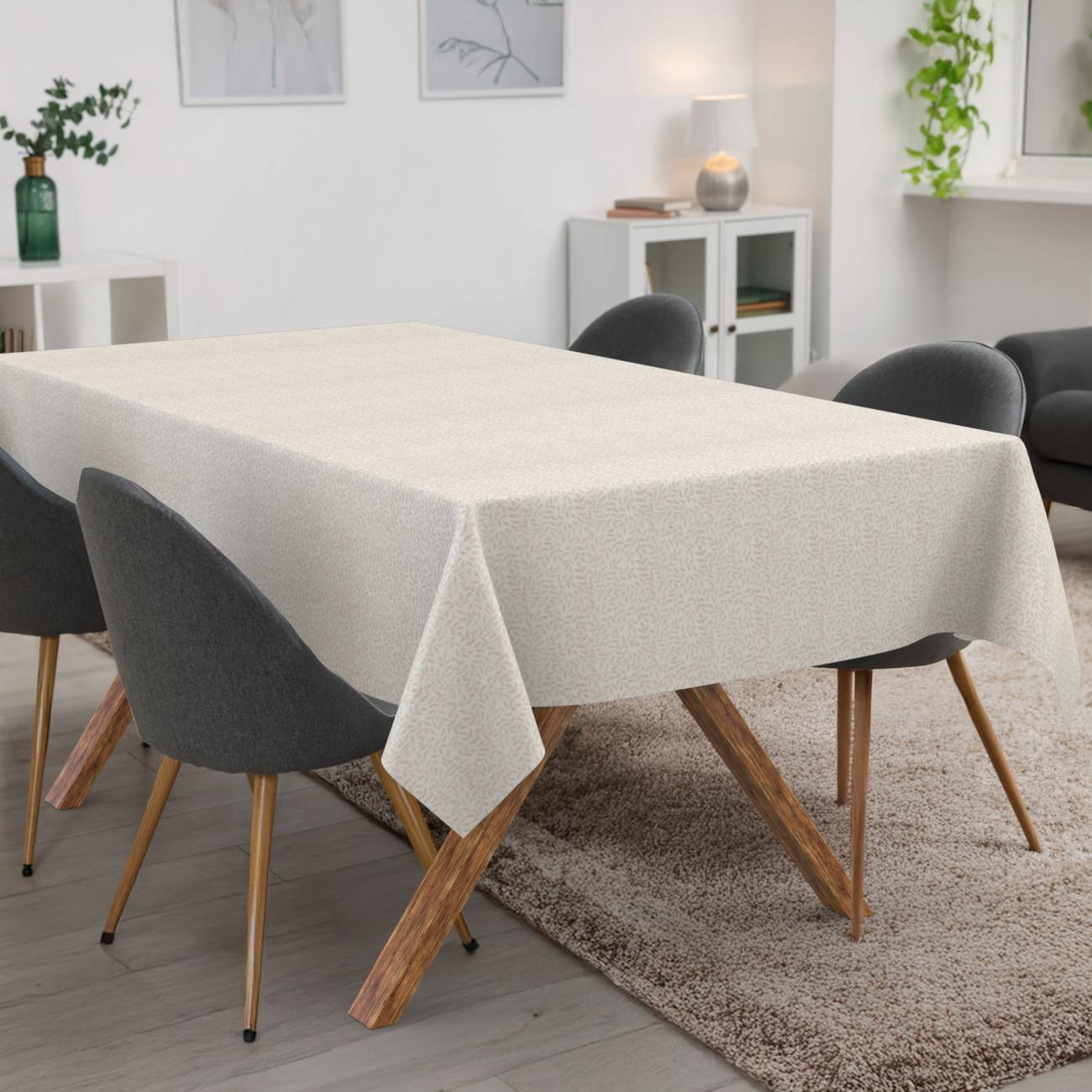 Ein modernes Esszimmer mit einem rechteckigen Tisch, der mit einer hellbeigen Tischdecke bedeckt ist, umgeben von vier dunklen Stühlen auf einem Teppich.