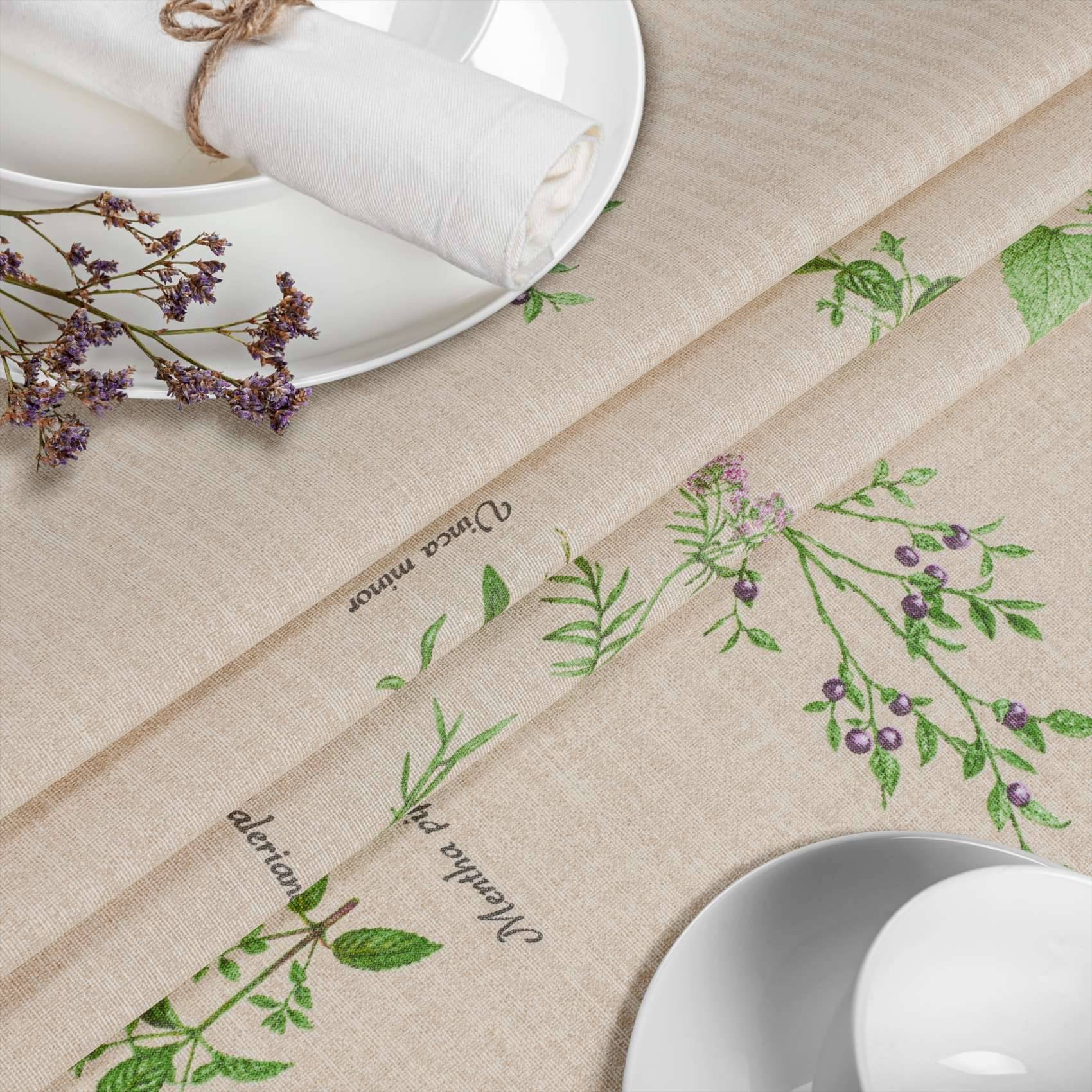Botanische Tischdeckung mit Lavendelzweigen auf beigefarbenem Leinen, dargestellt neben weißen Tellern und aufgerollten Servietten auf einer hellen Tischdecke.