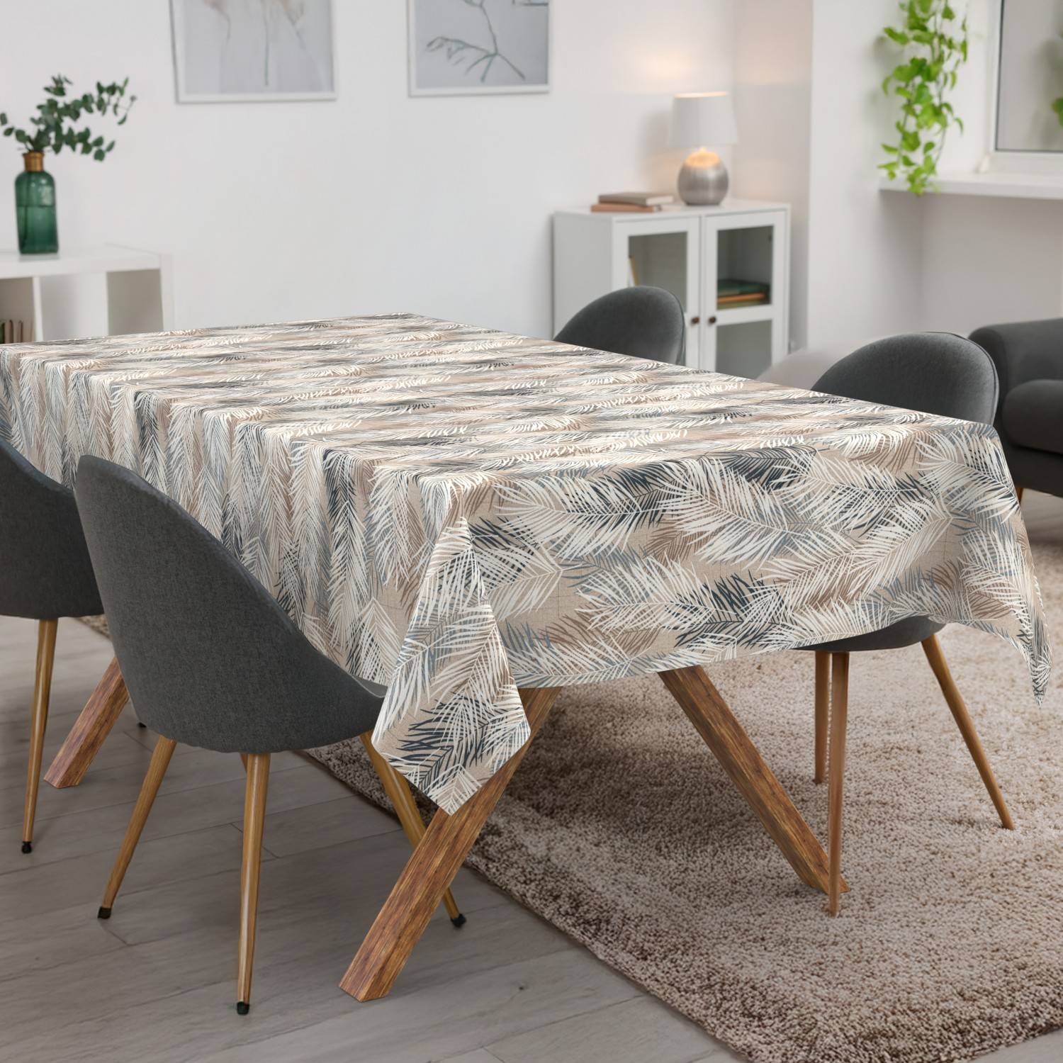 Esstisch mit gemusterter Tischdecke in einem hellen modernen Wohnzimmer, umgeben von grauen Stühlen und einem Teppich.