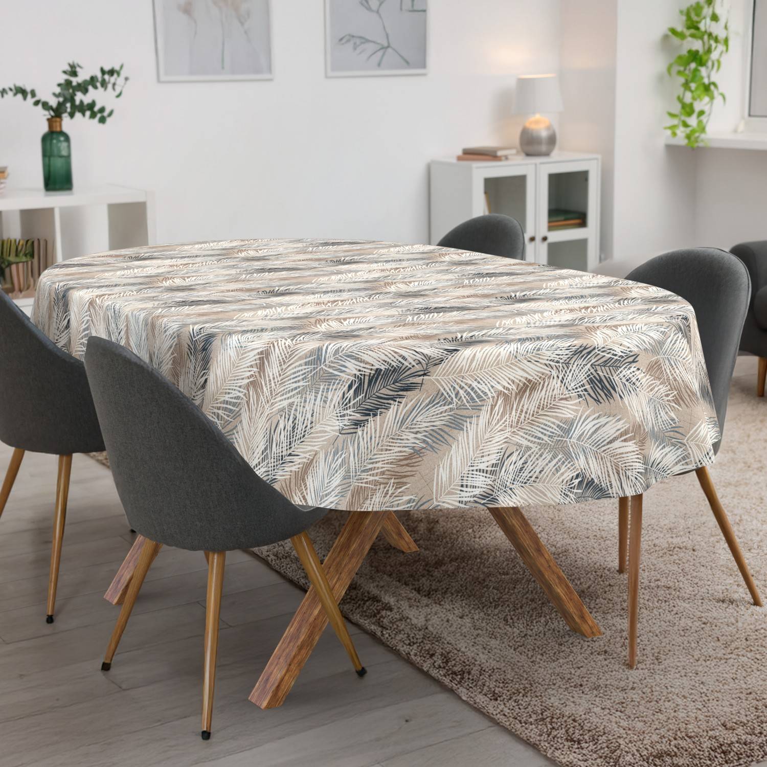 Esstisch mit einer blattgemusterten Tischdecke bedeckt, umgeben von vier grauen Stühlen in einem hellen modernen Raum.