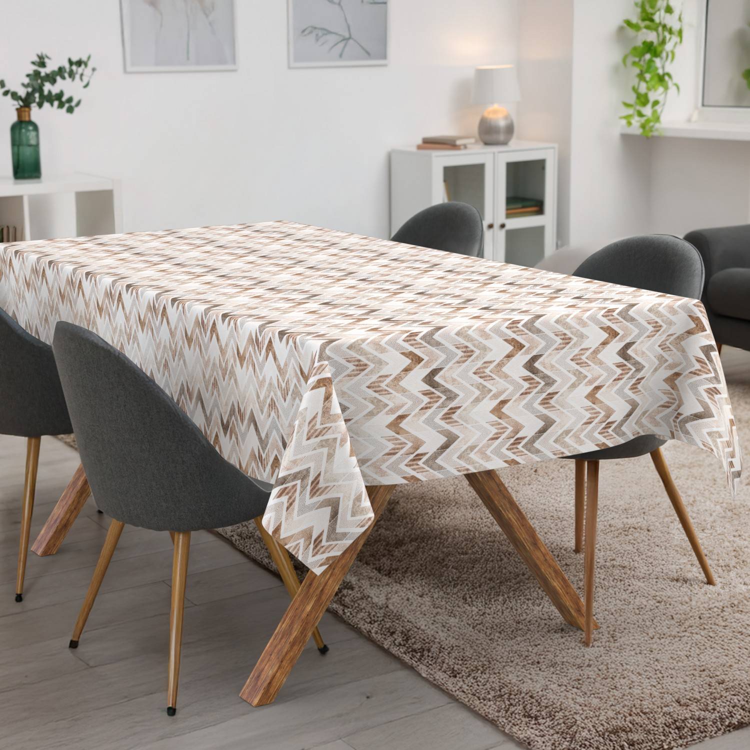 Esstisch mit gemusterter Tischdecke bedeckt, umgeben von dunklen Stühlen in einem hellen modernen Wohn-Esszimmer.