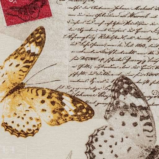 Nahaufnahme eines dekorativen Schmetterlingdrucks auf Stoff, mit einem gelbbraun Schmetterling und einem blassgefleckten Schmetterling über Schreibschrifttext.