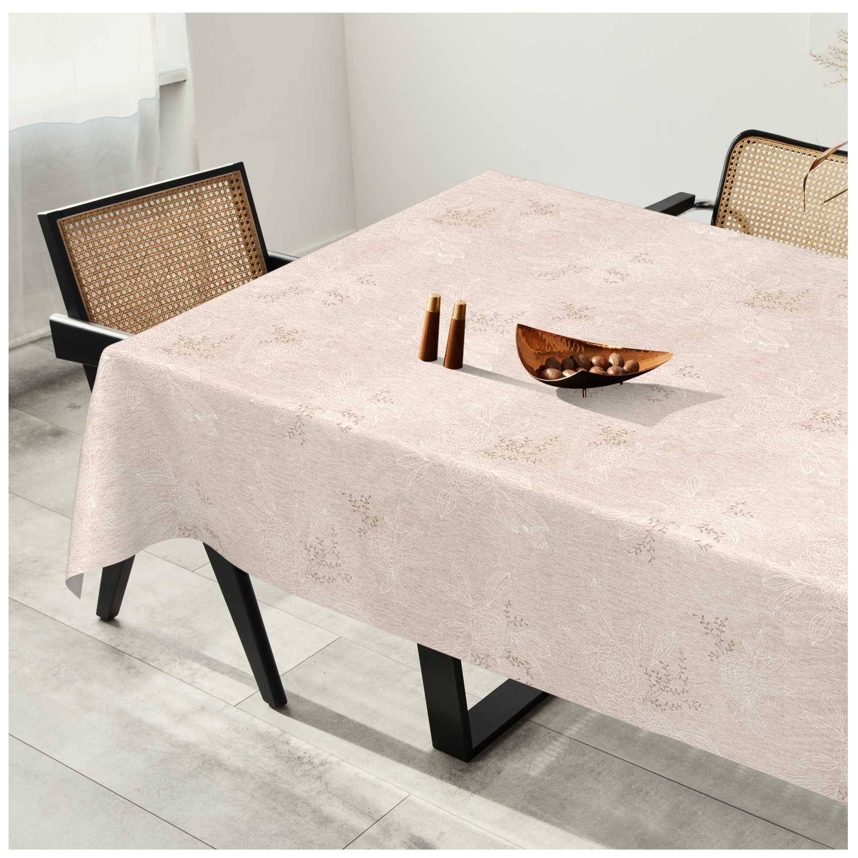 Ein Esstisch mit einem hellgemusterten Tuch, eingedeckt mit zwei kleinen Holzstreuern und einer dekorativen Schüssel, flankiert von zwei Stühlen mit Rohrgeflecht in einem hellen Zimmer.