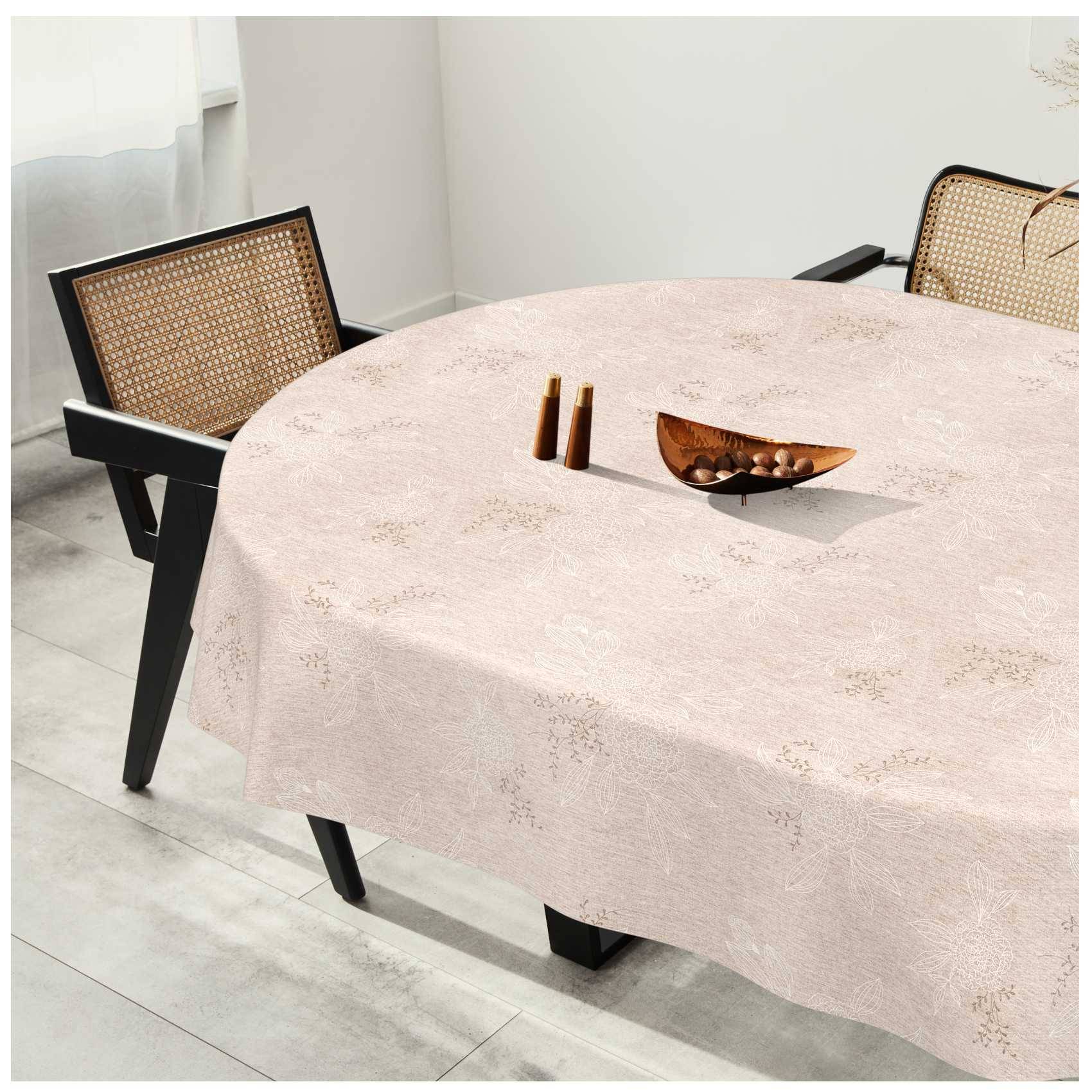 Runder Esstisch mit blassrosafarbenem Tischtuch, zwei Rattanstühle und kleine Holzdekoration in einem hellen, minimalistischen Raum.