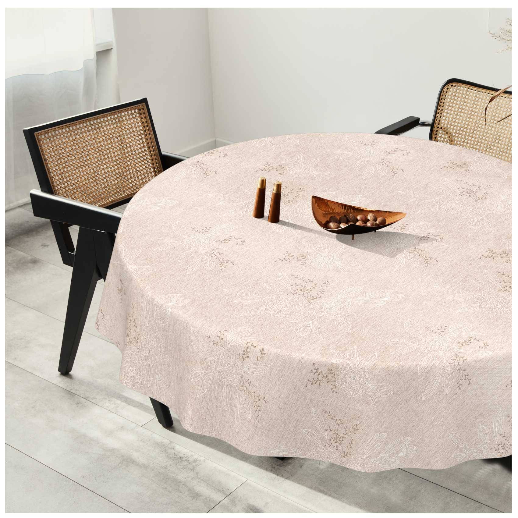 Runder Esstisch mit hellem strukturiertem Tischtuch, zwei Stühle mit Rattanrücken und einer Holzschale als Mittelstück in einem hellen Raum.