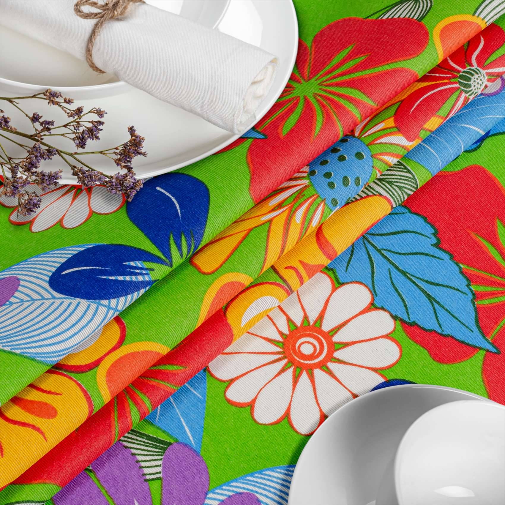 Farbenfrohe, gemusterte Tischdecke mit floralen Mustern, gefalteten Servietten und weißem Geschirr, gestaltet als helle Tischdecke.