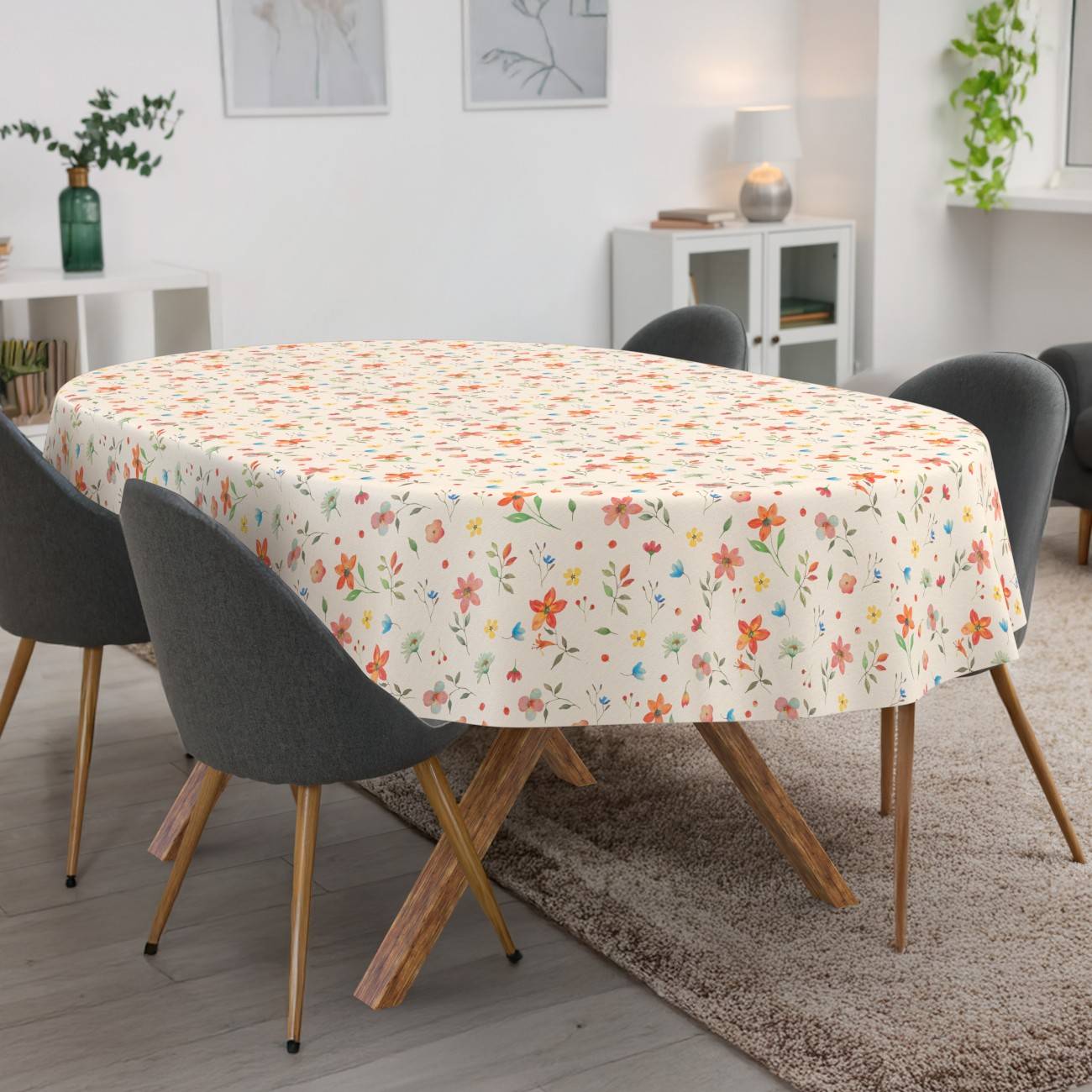 Ovaler Esstisch mit floraler Tischdecke, umgeben von vier dunkelgrauen Stühlen in einem hellen modernen Zimmer