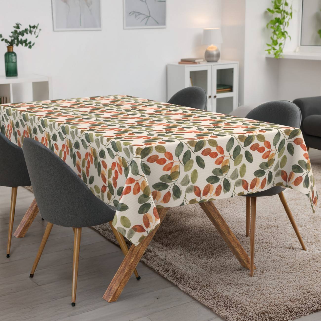 Esstisch mit einer farbenfrohen Tischdecke mit Blattmuster in einem modernen Wohnzimmer, umgeben von dunklen Stühlen.