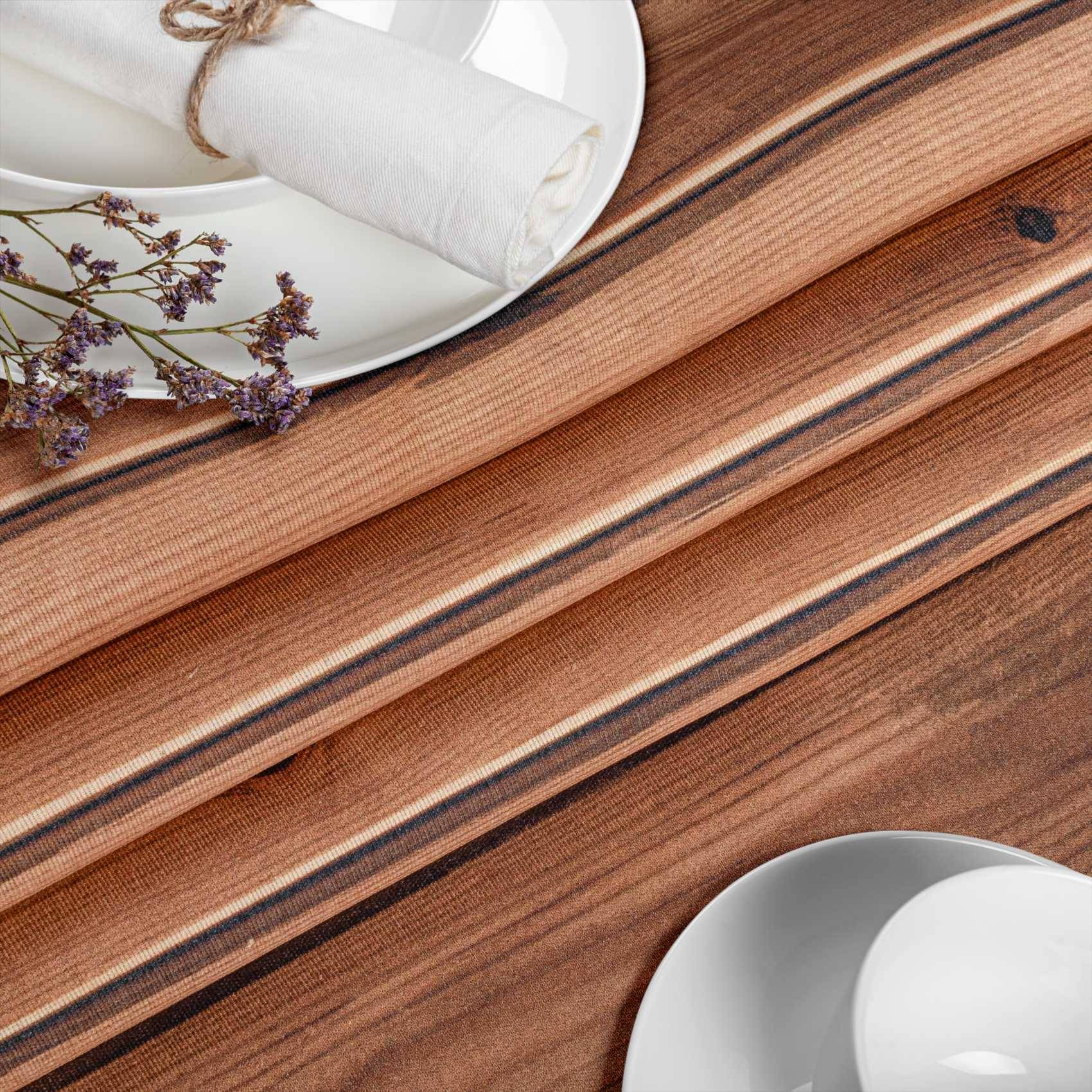 Holztisch mit weißem Teller, zusammengerollter Serviette, die mit Schnur gebunden ist, und kleinen violetten Blumen.