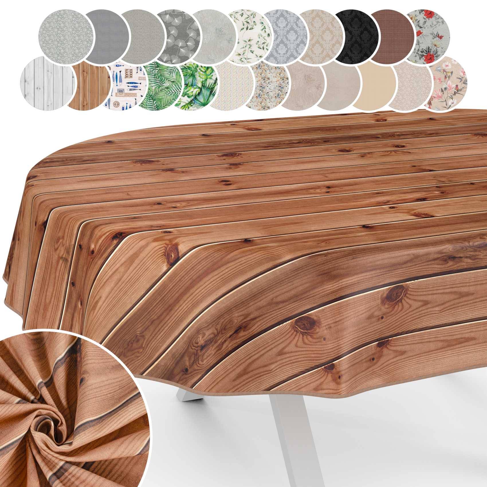Runder Tisch mit Holzoptik, über dem eine Tischdecke mit Holzmaserung drapiert ist, gezeigt mit mehreren Farb- und Musterstoffmustern oben darauf.