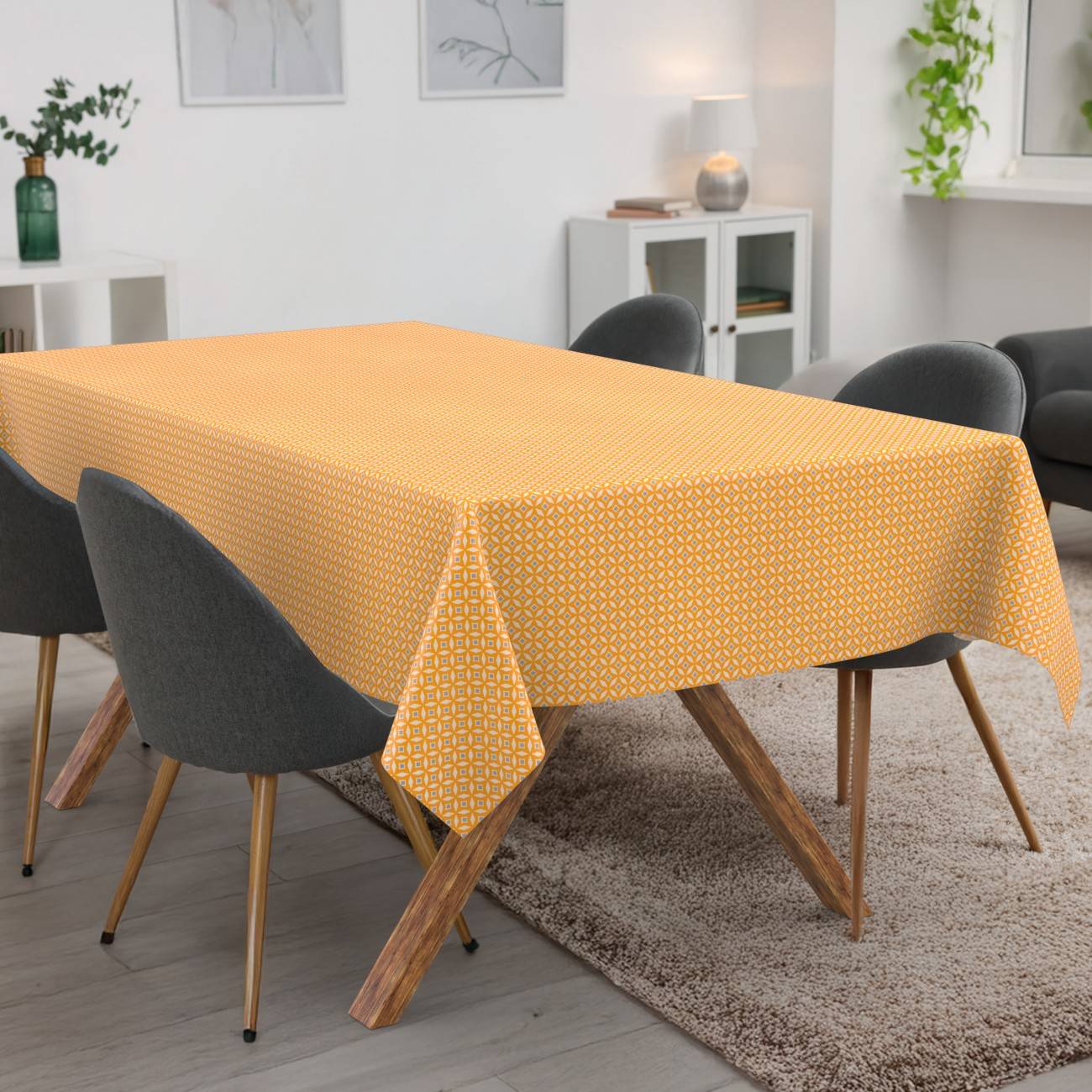 Esstisch mit einer gelb gemusterten Tischdecke in einem modernen Wohnzimmer, umgeben von dunklen Stühlen.