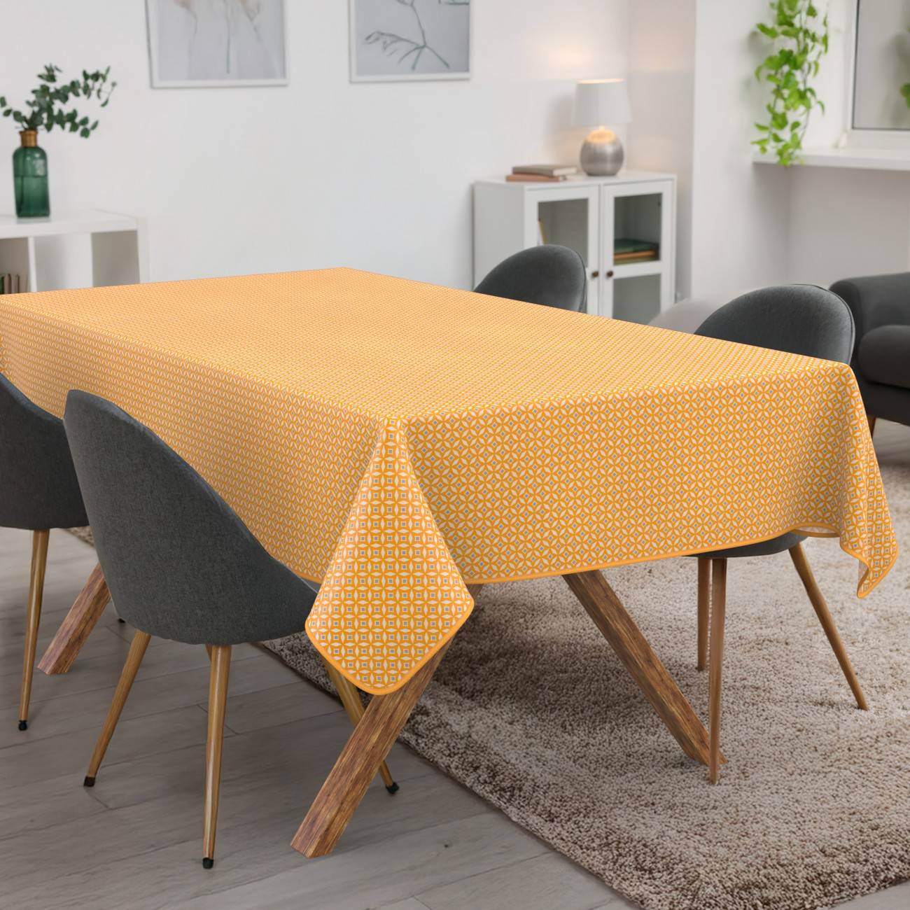 Esstisch mit einer gelben gemusterten Tischdecke in einem modernen Wohnzimmer, umgeben von dunklen Stühlen.
