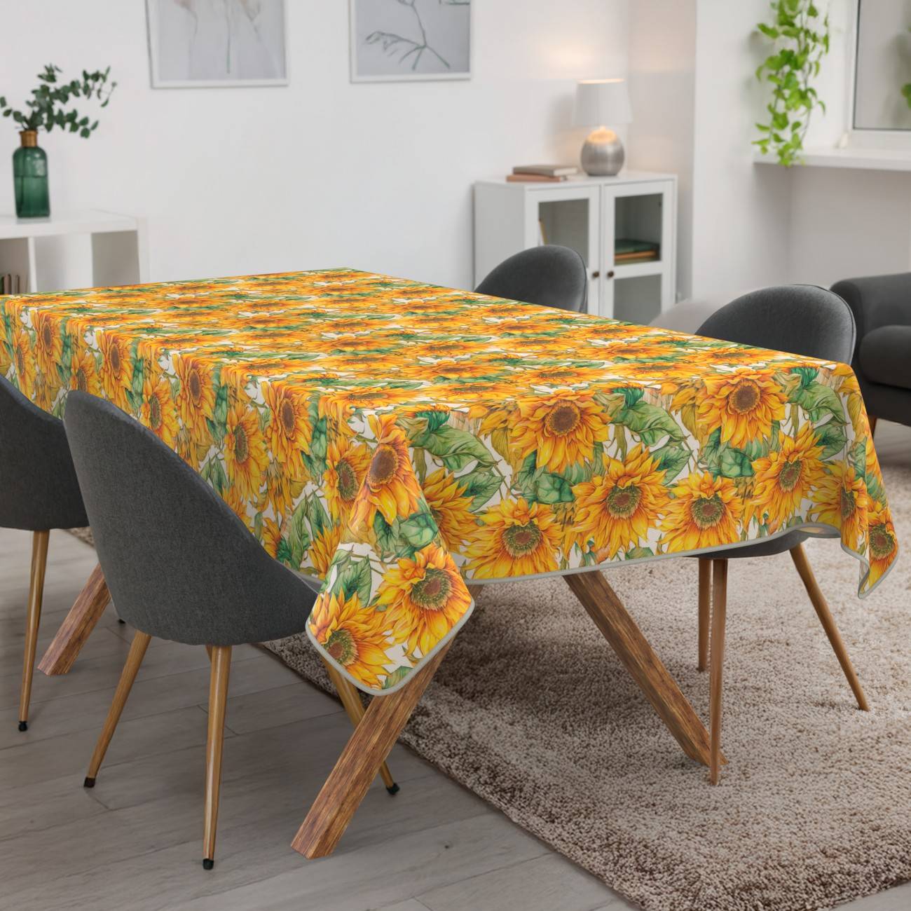 Esstisch mit einer leuchtenden Tischdecke im Sonnenblumenmuster in einem modernen Wohnzimmer mit dunklen Stühlen und einem beigen Teppich.