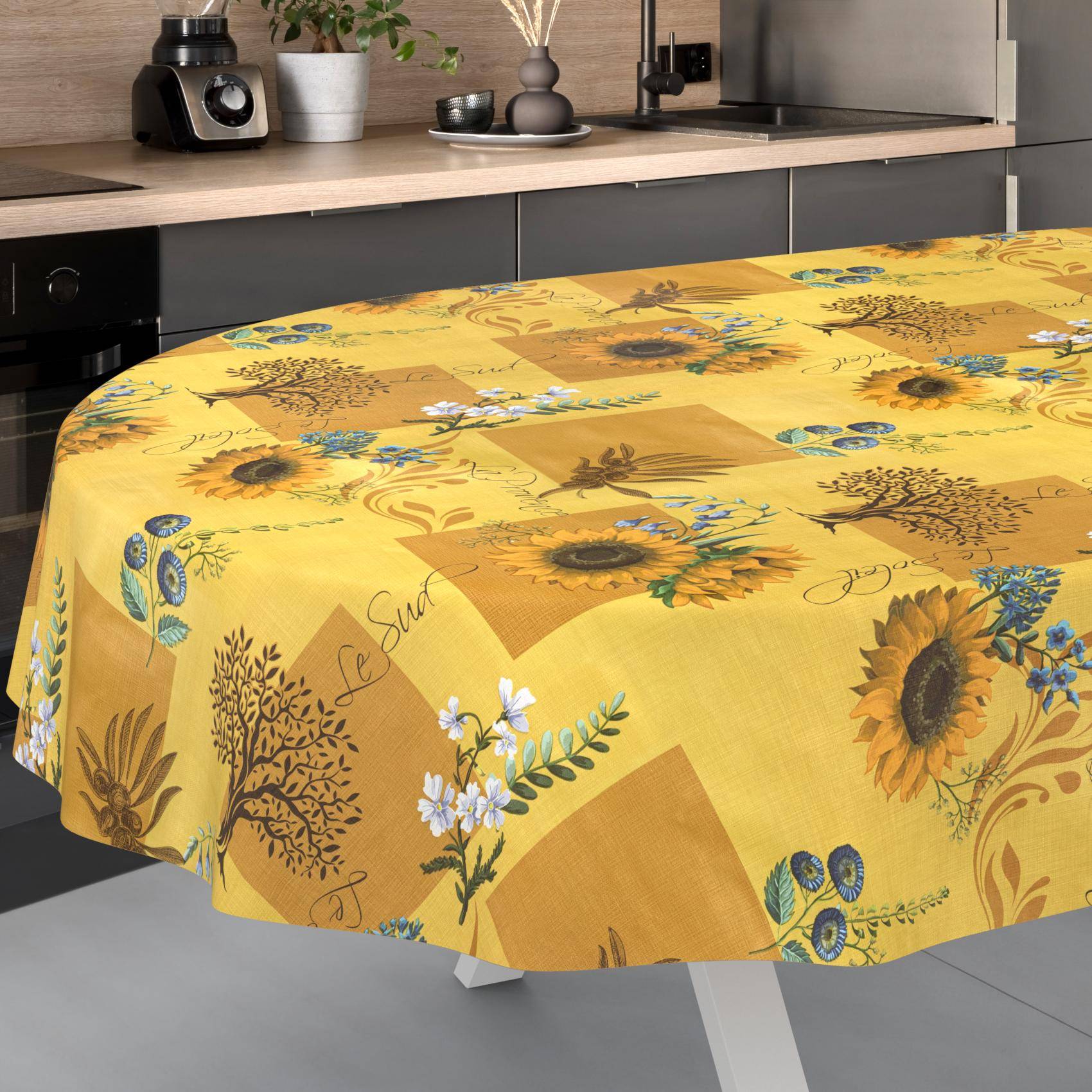 Runder Tisch mit einer gelben Blumentischdecke mit Sonnenblumen und botanischen Mustern in einer modernen Küche.