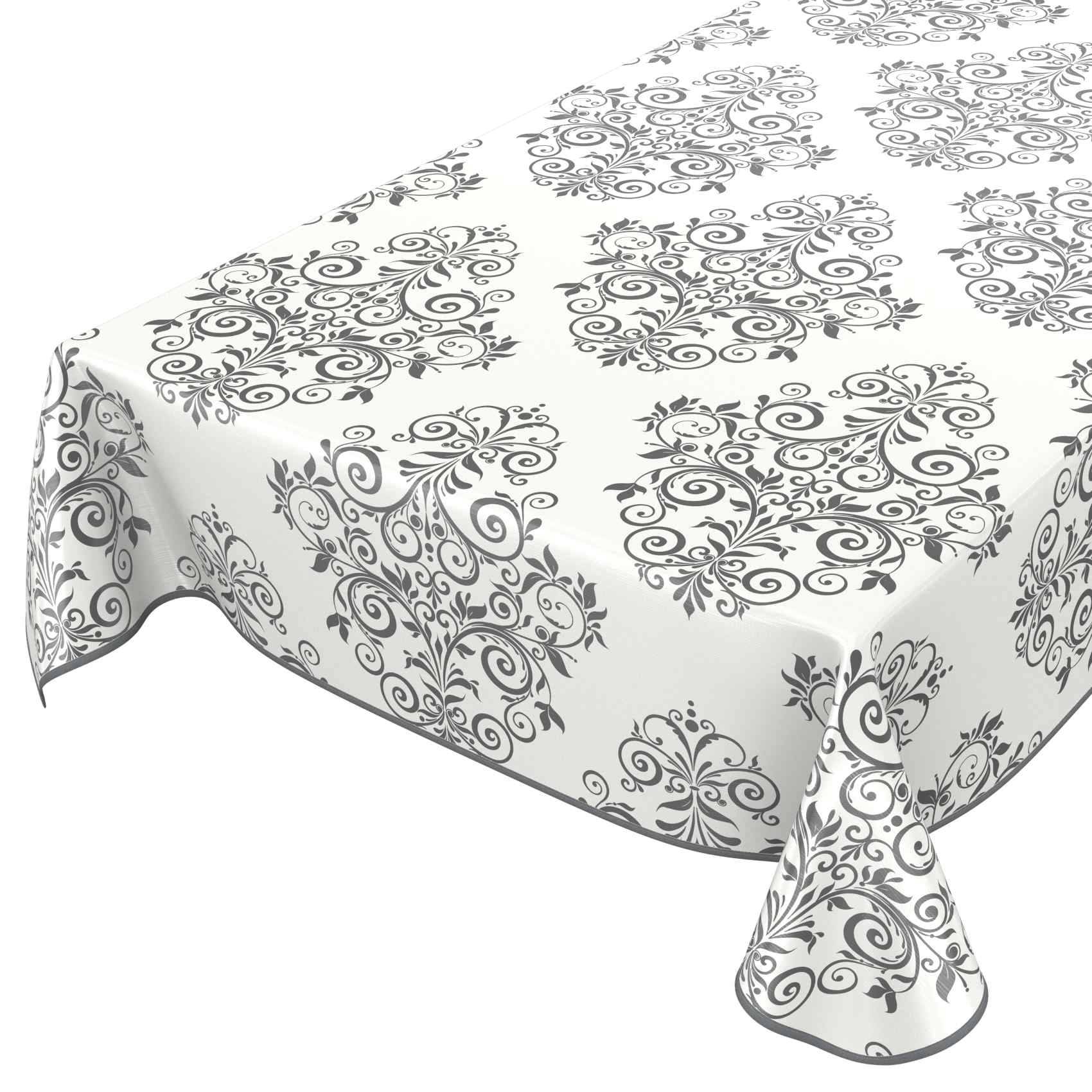Weiße Tischdecke mit grauem, ornamentalem Blütenranken-Muster über einem Tisch drapiert, mit einem passenden Servietten- oder Tuchstück vorne rechts.