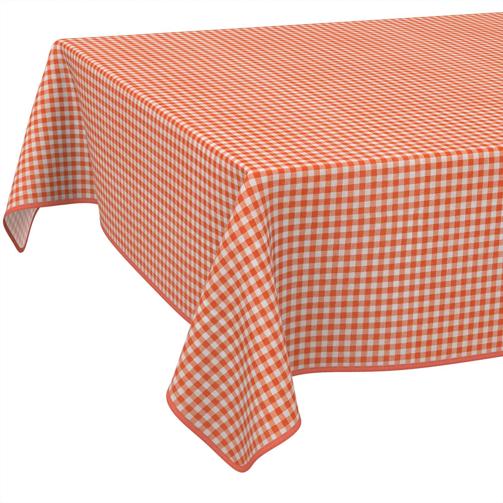 Orange-weiß kariertes Tischtuch, das über einen rechteckigen Tisch gegen einen einfachen weißen Hintergrund drapiert ist.