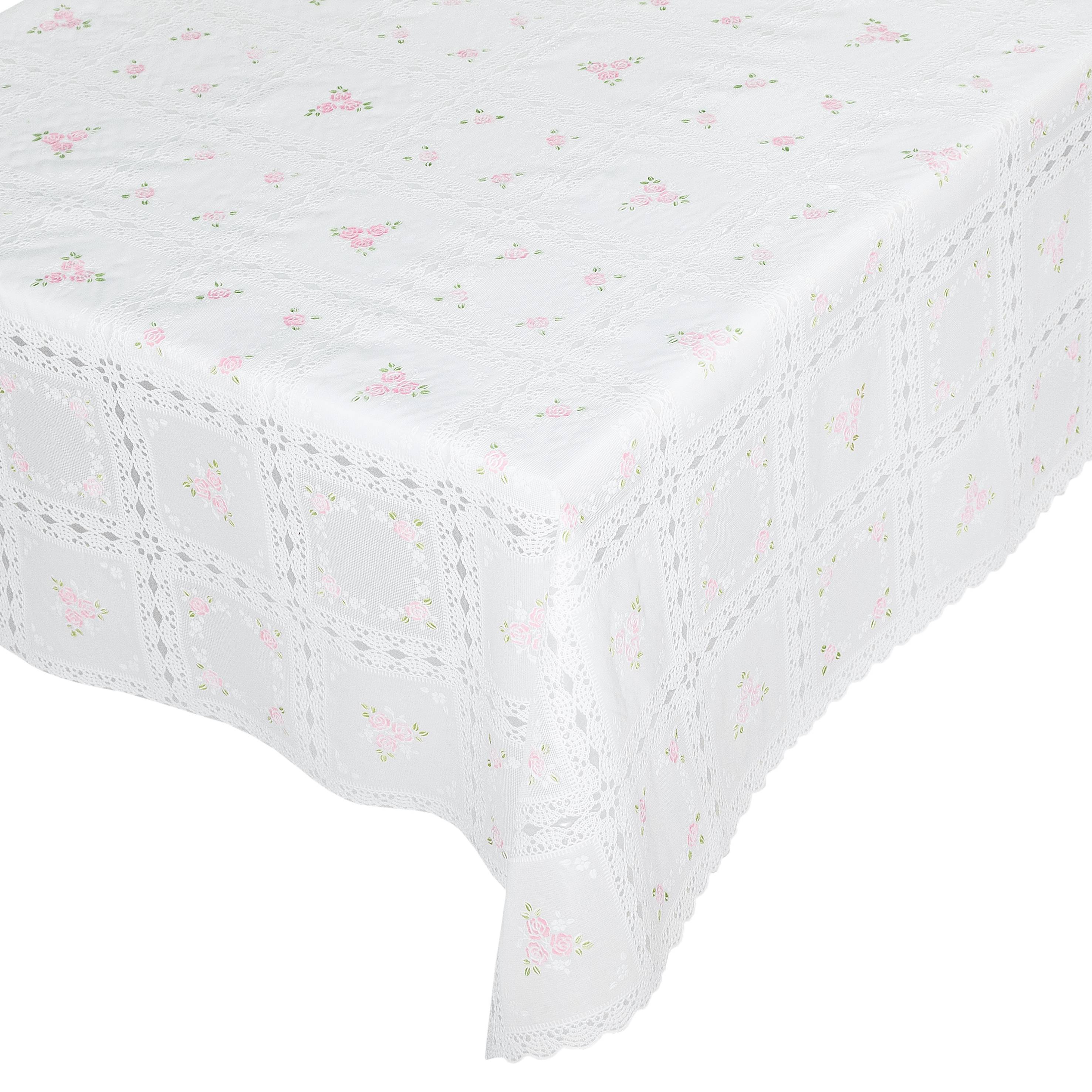 Weißes Spitzentischtuch mit gezacktem Rand und kleinem rosa Blumenmuster, über einem Tisch drapiert.