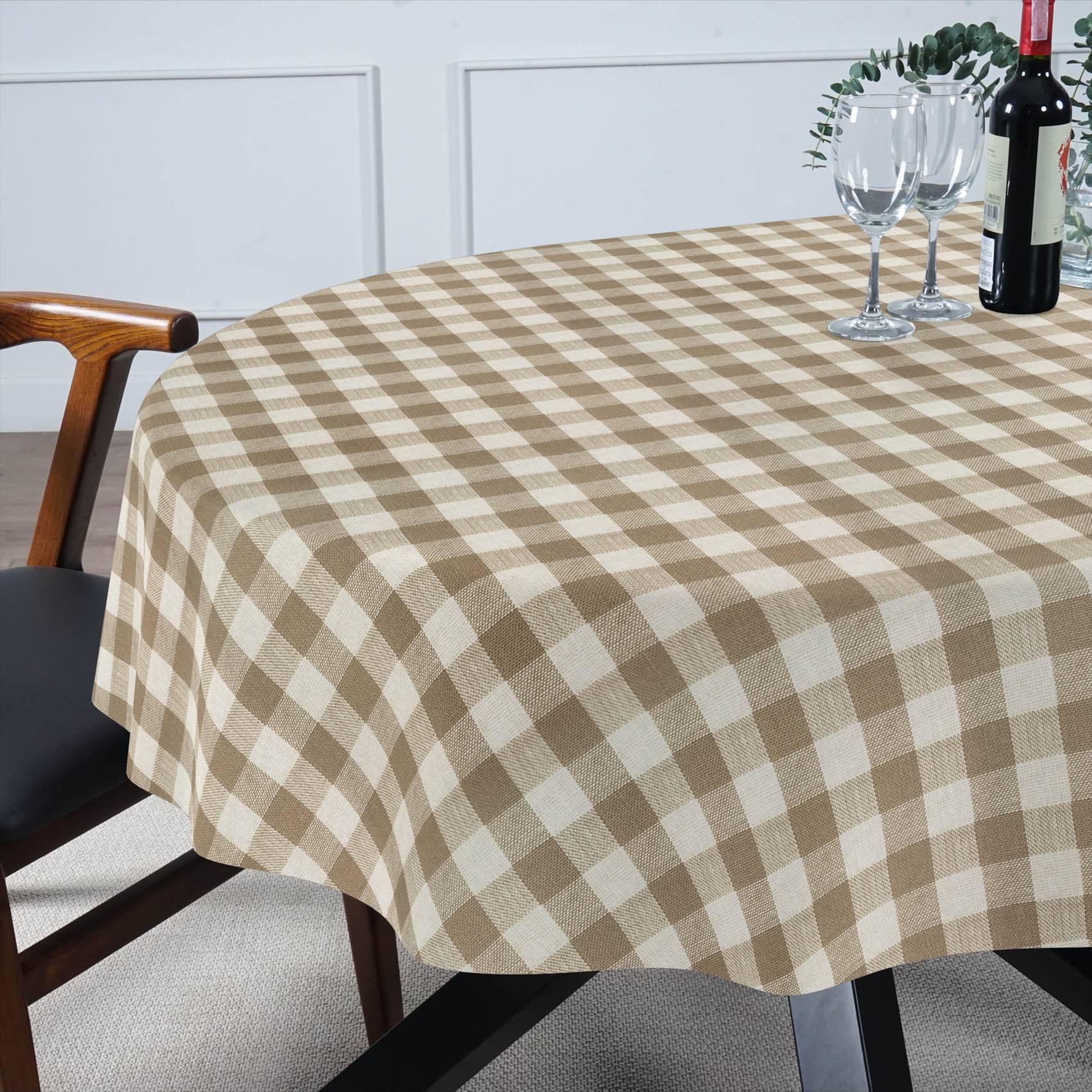 Beige-weiße karierte Tischdecke, die einen Esstisch bedeckt, mit Weingläsern, einer Flasche und einem Stuhl daneben.