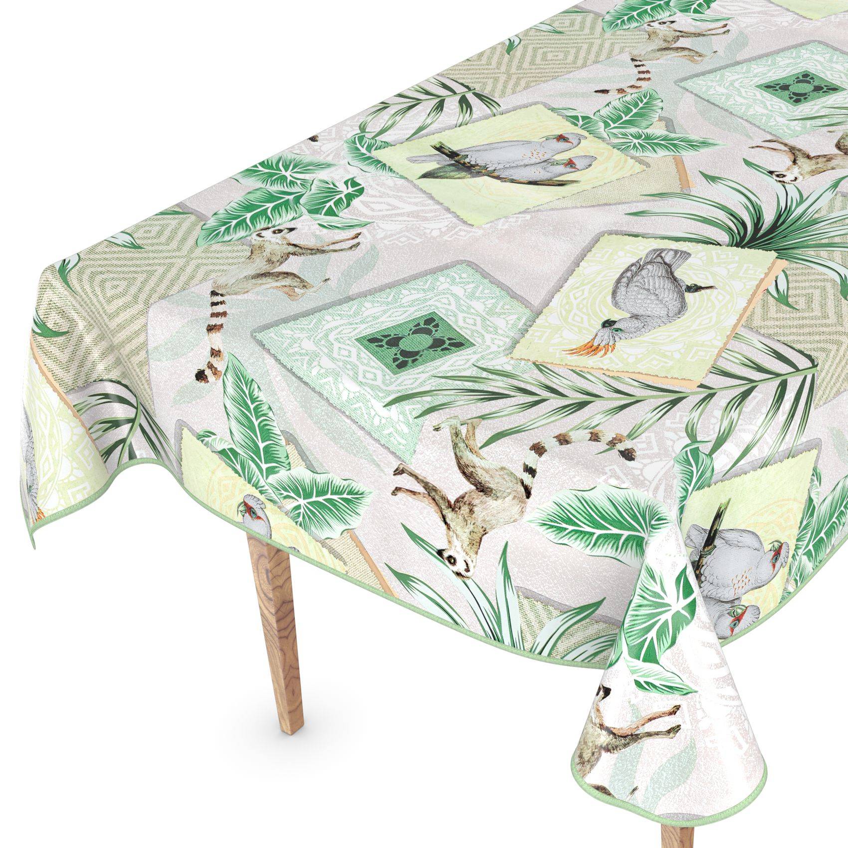 Tischdecke mit Vogel- und Tropenblatt-Muster, das über einen rechteckigen Tisch drapiert ist, mit einem sichtbaren einzelnen Holzbein.