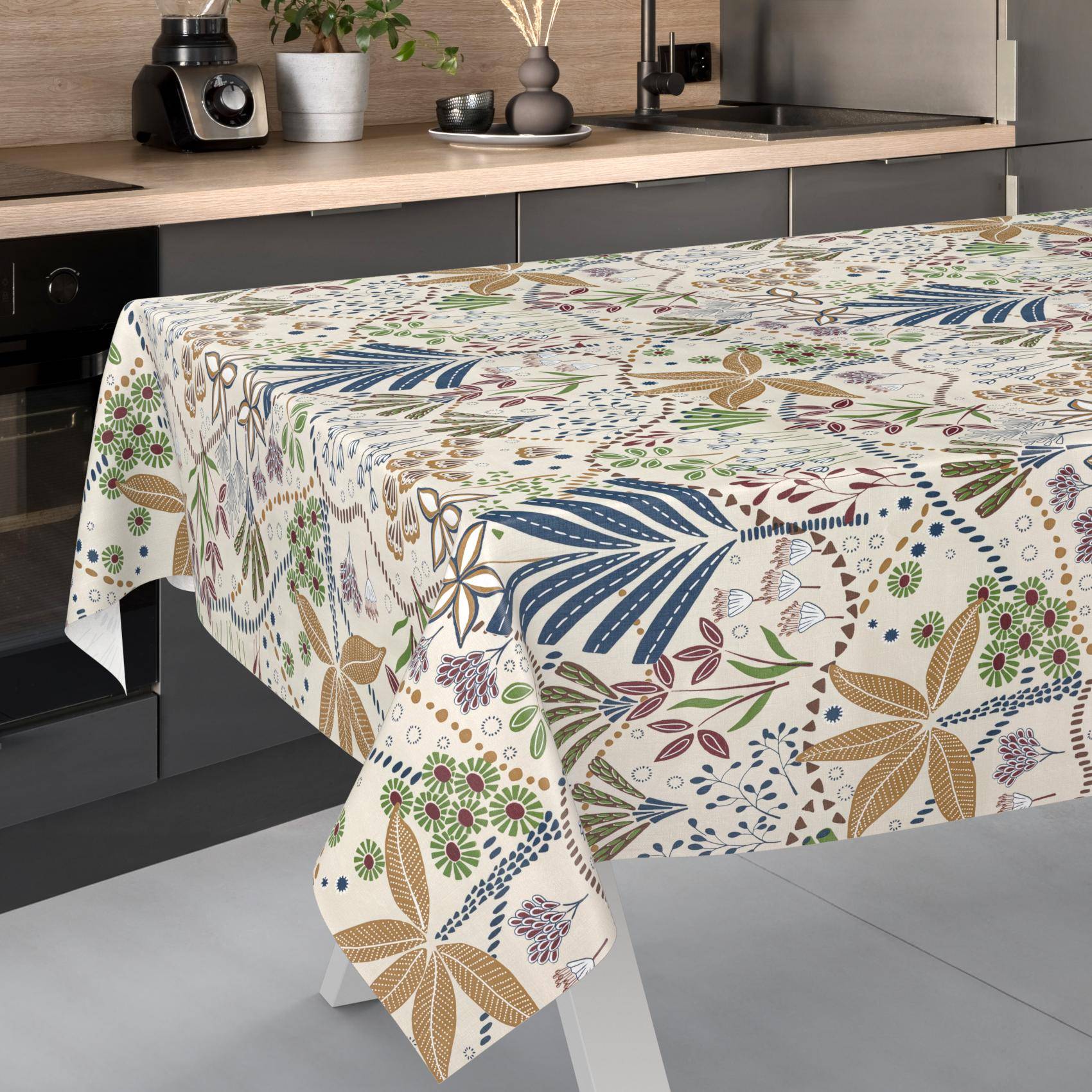 Gemustertes Tischtuch mit botanischem und Blumendruck über einem Tisch in einer modernen Küche drapiert.