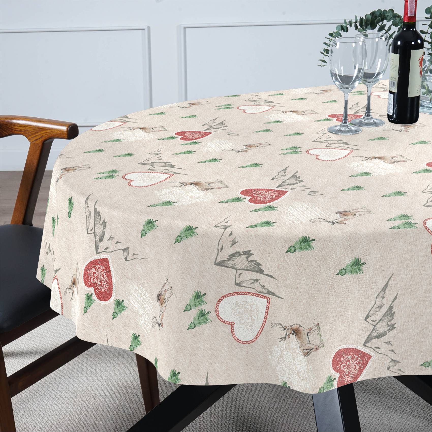 Esstisch mit beigefarbiger herzgemusterter Tischdecke, eingedeckt mit Weingläsern und einer Flasche neben einem Stuhl.