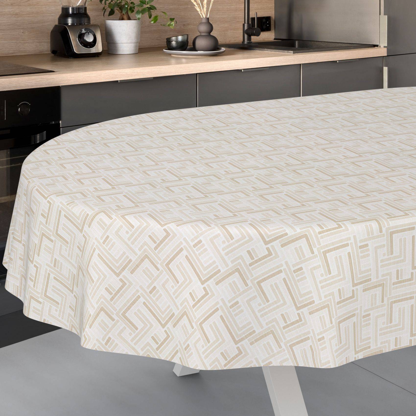 Runder Tisch mit einer beigefarbenen geometrisch gemusterten Tischdecke in einer modernen Küche.
