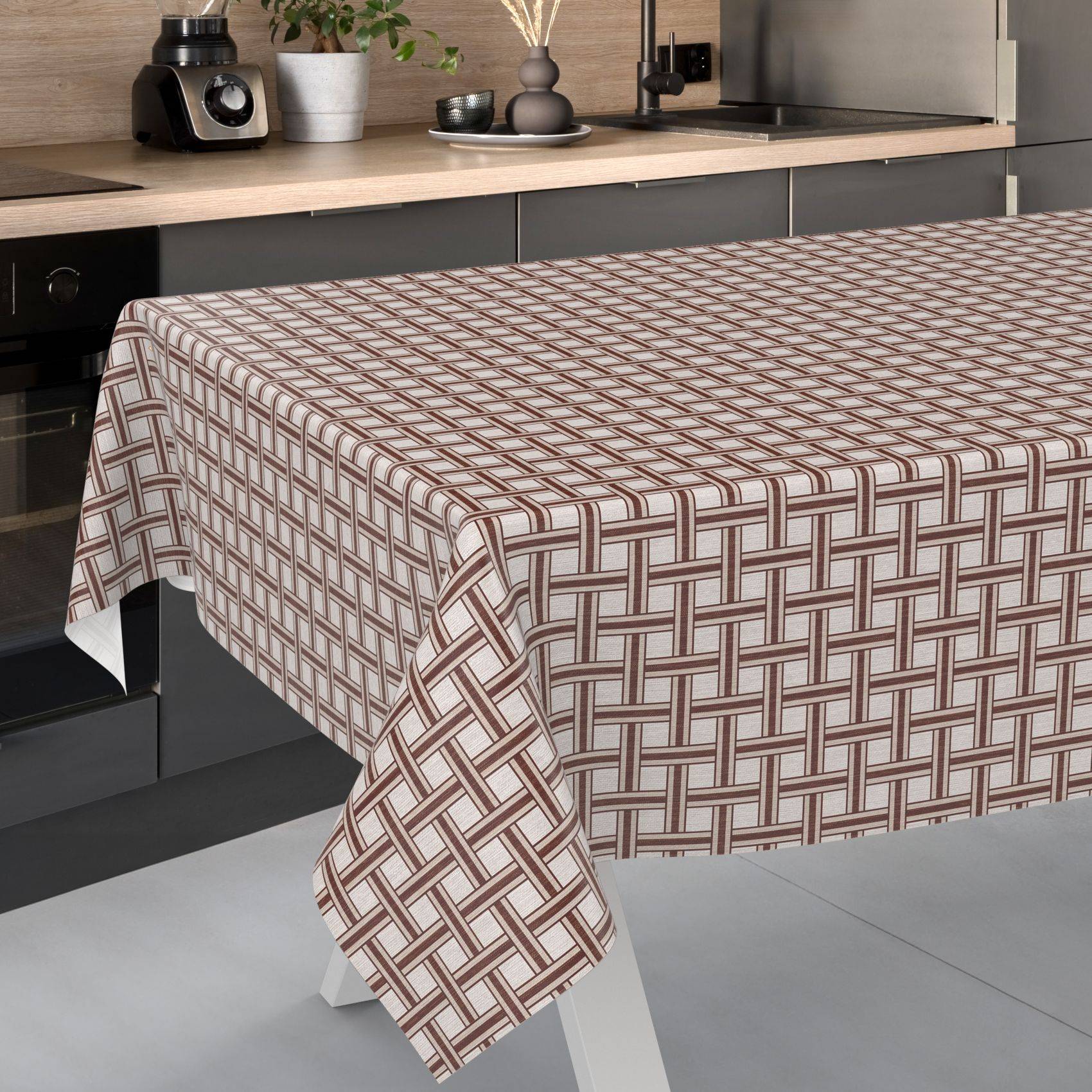 Quadratischer Tisch mit einer beige und braun gemusterten Webstoff-Tischdecke in einer modernen Küche.
