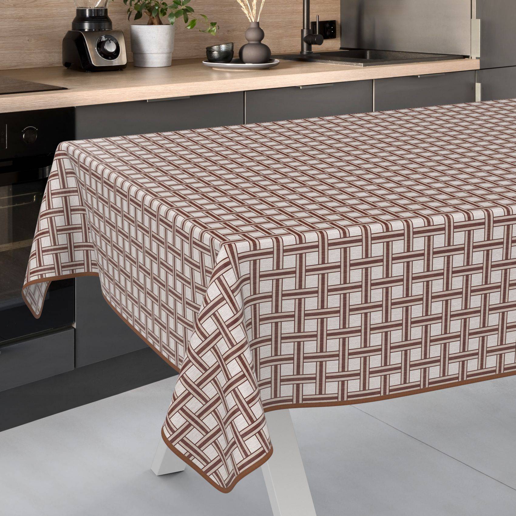 Ein Küchentisch, bedeckt mit einer braun-weißen geometrischen karierten Tischdecke.