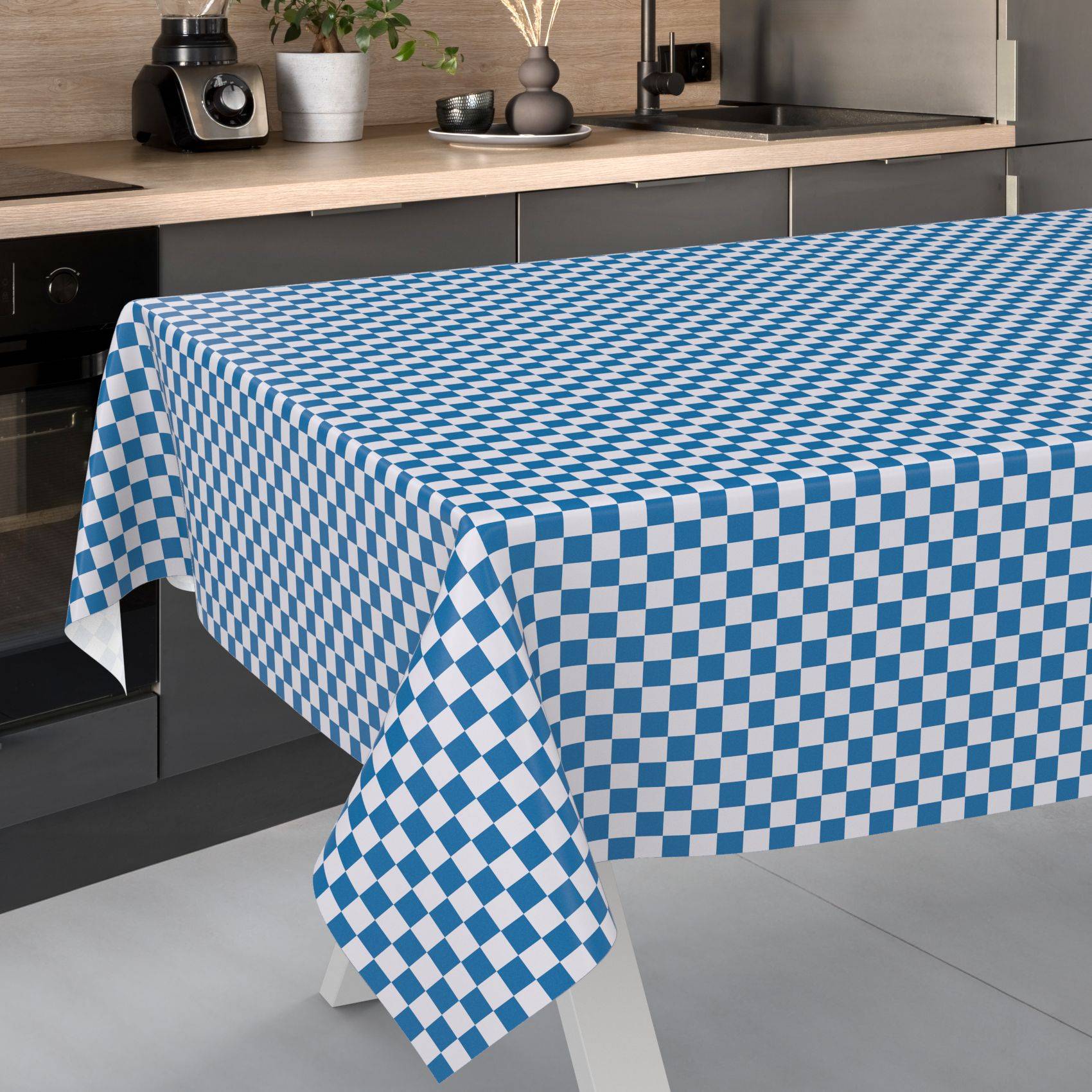 Blau-weiße karierte Tischdecke, die über einen rechteckigen Esstisch in einer modernen Küche drapiert ist.