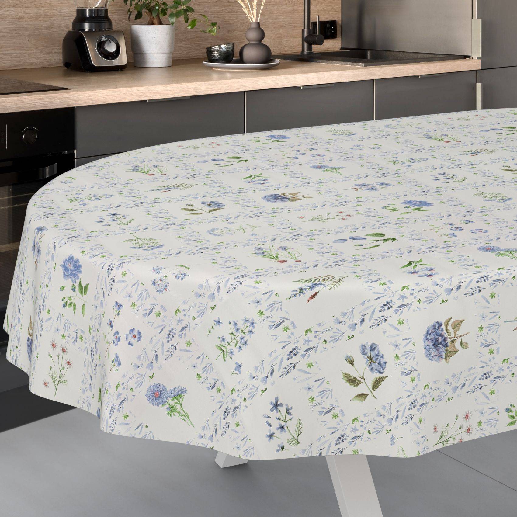 Tischdecke mit Blumenmuster, die über einen Esstisch in einer modernen Küche drapiert ist.