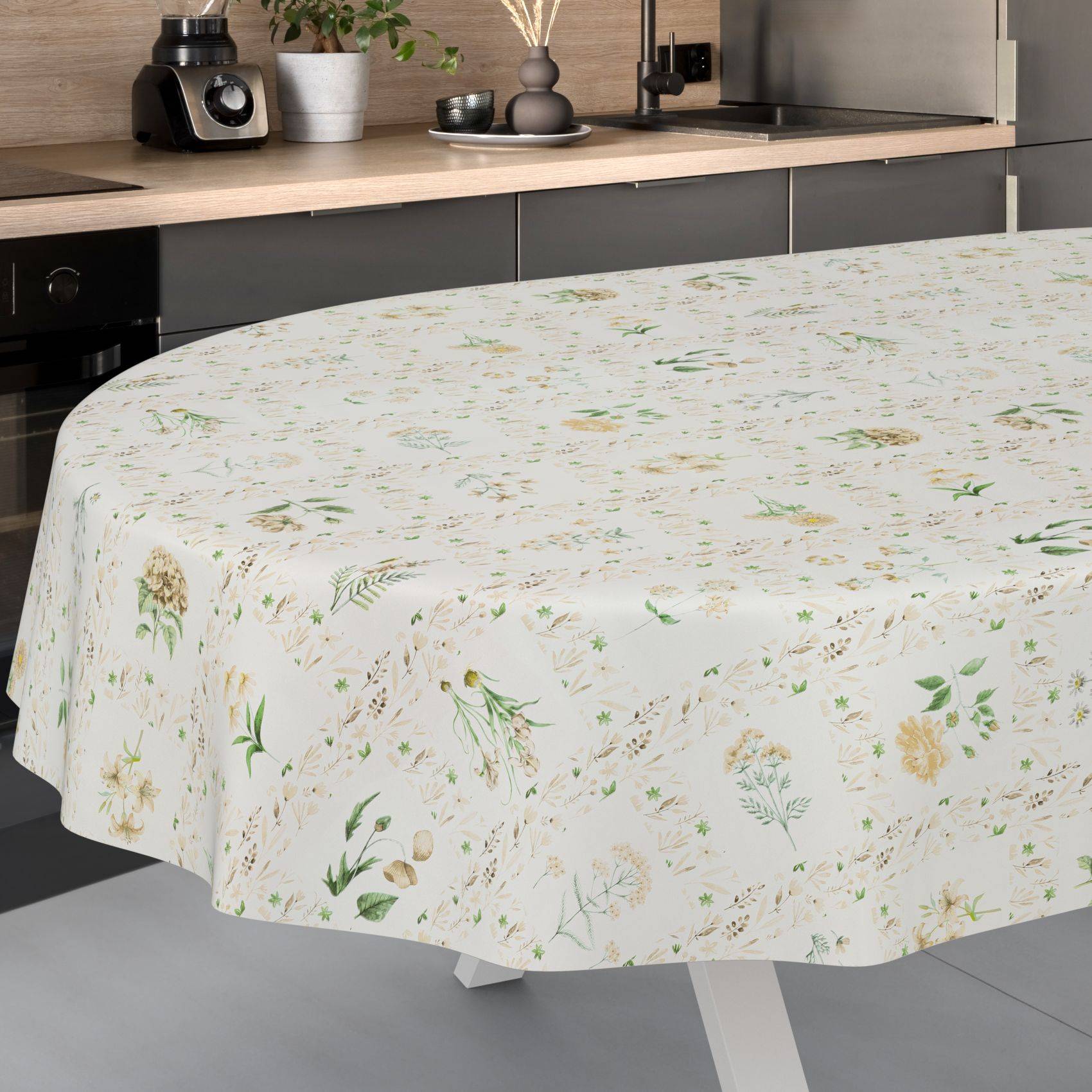 Tischdecke mit Blumenmuster über einem runden Tisch in einer modernen Küche drapiert.