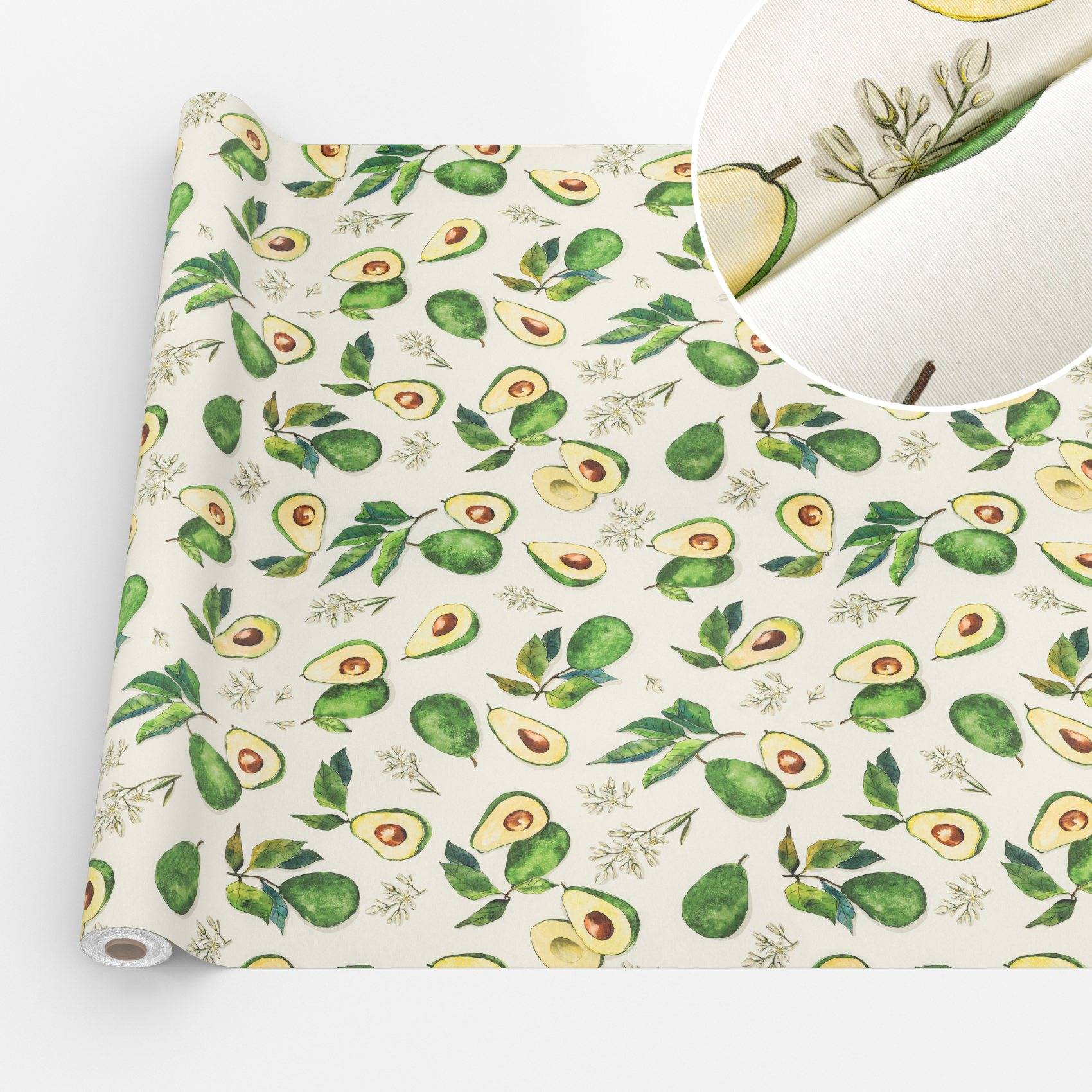 Rolle mit Avocado-gemustertem Stoff mit grünen Blättern und geschnittenen Avocados auf weißem Hintergrund; Ausschnitt zeigt die Materialtextur.