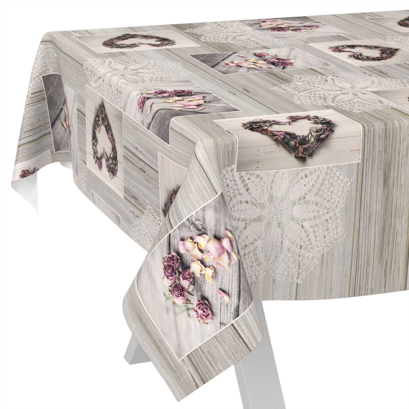 Rechteckige Tischdecke mit grauer Holzmaserung und Spitzendruck, verziert mit floralen Herzmotiven, über einem Tisch drapiert.