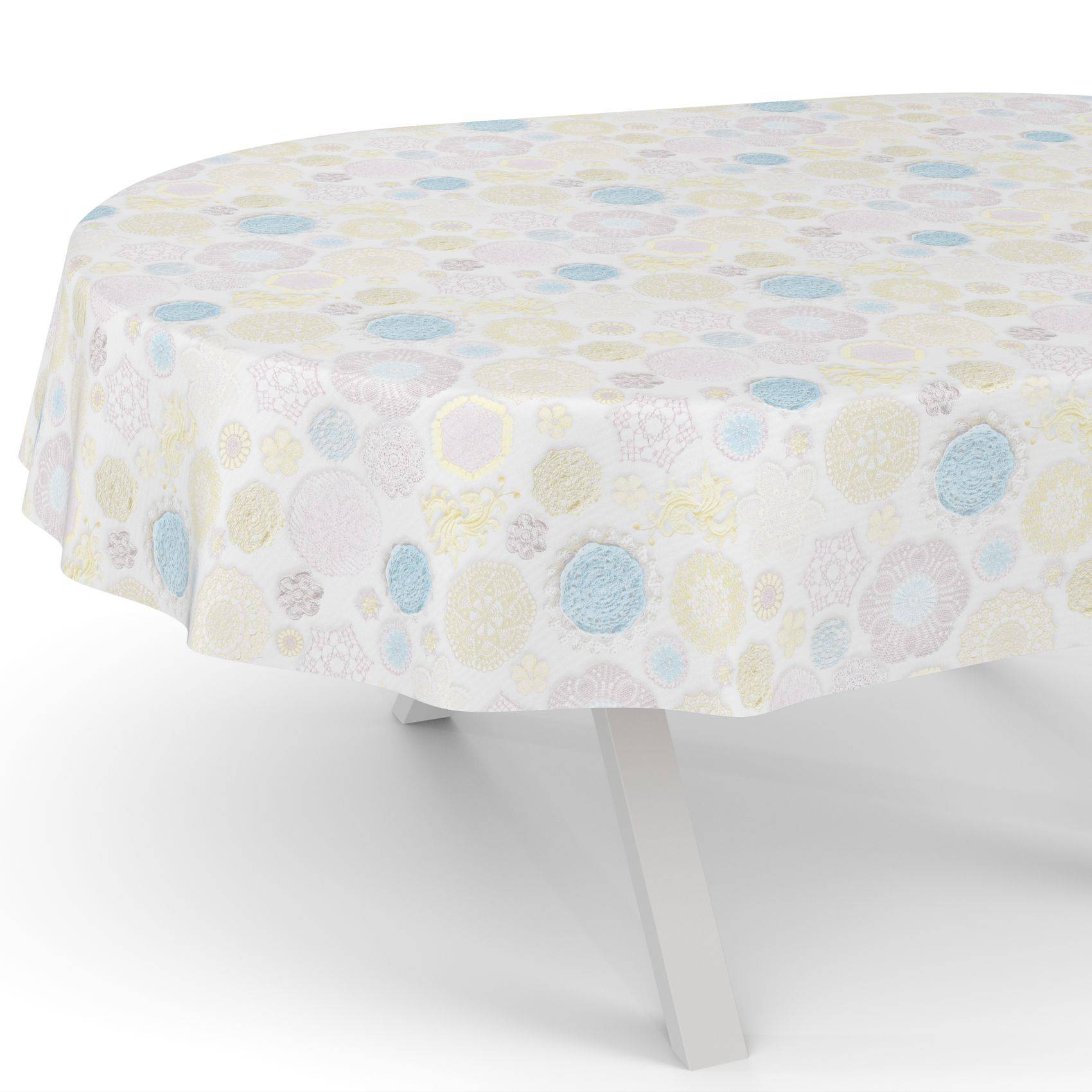 Runder Tisch mit einer weißen Tischdecke, die mit pastellfarbenen Kreisen und Blumenmotiven gemustert ist.