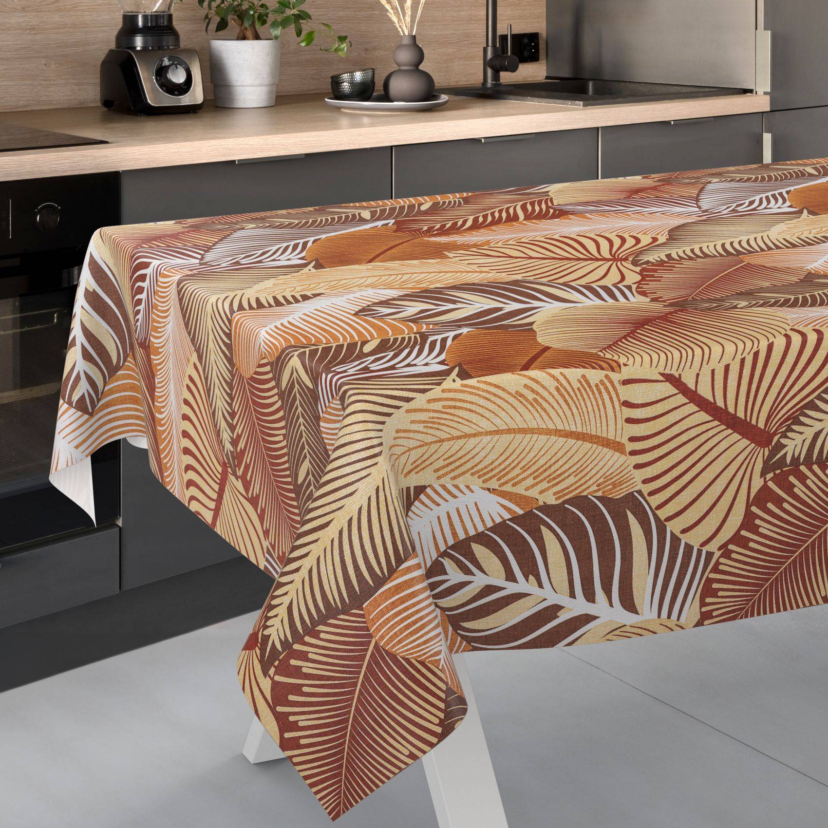 Gemustertes Tischdecke mit beige-, braun- und rostfarbenen Blattmustern, das über einem Tisch in einer modernen Küche drapiert ist.