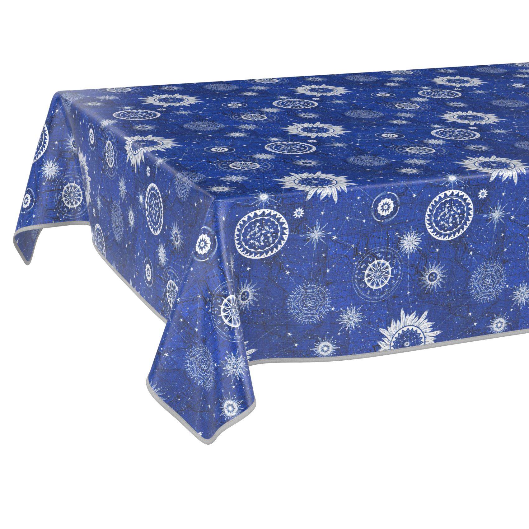 Blaue Tischdecke mit weißen Schneeflocken- und Starburst-Mustern auf einem rechteckigen Tisch vor einem einfachen weißen Hintergrund.