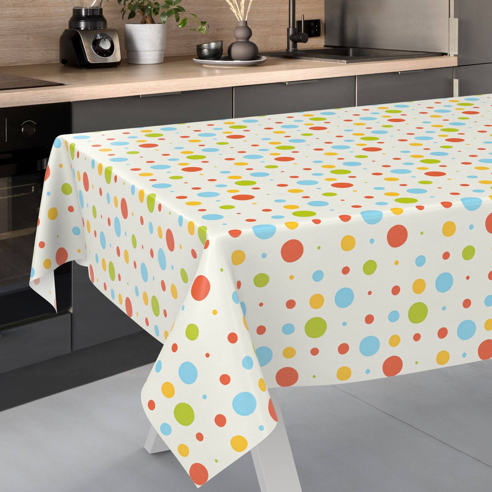 Küchentisch mit einer weißen Tischdecke mit roten, blauen, gelben und grünen Punkten bedeckt.